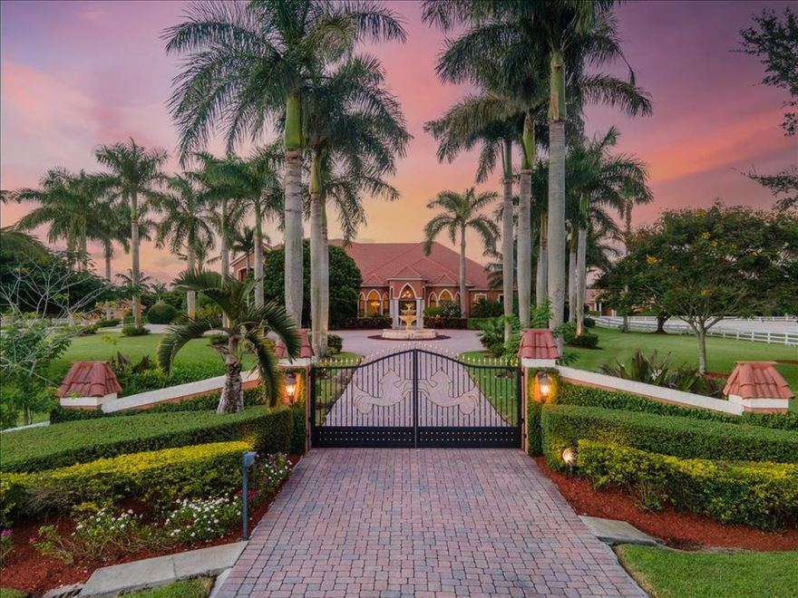 Dazzling, Desirable and a Deal! This stunning property and home, in exclusive & gated Palm Beach Point, sits on 7+ acres within an easy hack to WEF and offers everything you want and enough room to keep dreaming! 
Separate entrances to the home and barn provide privacy and ease. As you enter the entrance to the home, there is an equestrian themed gate that opens up to a grand Royal Palm tree-lined driveway with a fountain that will wow your guests. It only gets better as you enter this immaculate 4 bedroom, 5-1/12 bath home that was recently renovated by one of the top designing firms in the country. The living room looks out over the inviting pool and entertainment area that includes a gazebo covered sitting area with a fireplace, outdoor kitchen, large hot tub and a pool with a sitting bar area. The formal dining room shines with a spectacular Venetian chandelier purchased specifically for this home in Murano, Italy. The open well- appointed kitchen includes stainless steel appliances, a Thermador 6-burner gas range, warming drawer, double ovens and a large working island. With two pantries and an additional Butler's pantry, there is plenty of room for all your entertaining needs. The kitchen looks out over the magnificent cathedral ceiling in the family room that includes a fireplace and double sided aquarium. The aquarium divides the family room from a  bar area that is set up for hosting wonderful gatherings and enjoying wines from the built-in 1100 bottle temperature controlled wine cellar. The stunning master suite also boasts a fireplace, as well as a private patio that provides privacy, but overlooks the riding ring and barn. The marble master bath has an oversized shower and a jacuzzi tub with separate vanities and a massive closet. Two large additional bedrooms and an office/bedroom all have their own private ensuite bathrooms. A second floor loft has a pool table, game table, and additional seating area inside and an expansive patio that overlooks your gorgeous property with amazing sunset views. You're ready for any storm that may come your way with a generator that runs the entire house and storm shutters. 

The 8-stall barn can be easily enlarged with plenty of space to add more stalls or an additional barn. A studio apartment with a full bath, a laundry room with an additional half bath, feed room and two air conditioned tack rooms provide the room you need and look out over the 185' x150' riding arena and 4 paddocks. There's more room to grow on this equestrian's dream property that is priced to sell and move in ready!