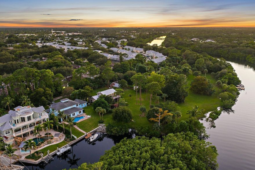 Tucked away on one of Jupiter's most private, little-known streets, this half-acre waterfront property captures the quiet beauty of Old Florida. The lot spans approximately 150 by 150 feet, surrounded by nature and calm water views that feel worlds away, yet you're in town, only minutes from I-95, beaches, and everything Jupiter has to offer.The existing two-story, three-bedroom plus den home offers solid bones, a comfortable layout, and a large screened-in patio overlooking the expansive backyard and water. A detached garage provides extra storage or workspace, and with no HOA, there's plenty of room for your boat, RV, or future additions.From your backyard, you can build your own dock and head out for a ten-minute ride to the Jupiter Sandbar or fifteen minutes to the inlet.