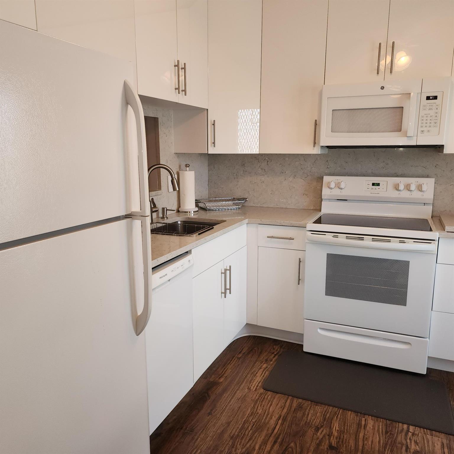 Delight in the harmony of simplicity and elegance with this corner unit situated in the vibrant and active 55+ community in Boynton Beach, Florida. Sitting just a mere 1.5 miles from the enchanting coastline, this locale offers a rare opportunity to enjoy both tranquility and entertainment. The pride of this property is the smartly renovated kitchen that speaks volumes of efficiency and style. The pristine quartz countertops, paired with a full backsplash, inject a sophisticated note of modern luxury, while the ceiling-reach cabinets provide ample storage without compromising aesthetics. The property presents an ambience of warmth, welcomeness, and serenity that is visually and functionally captivating.