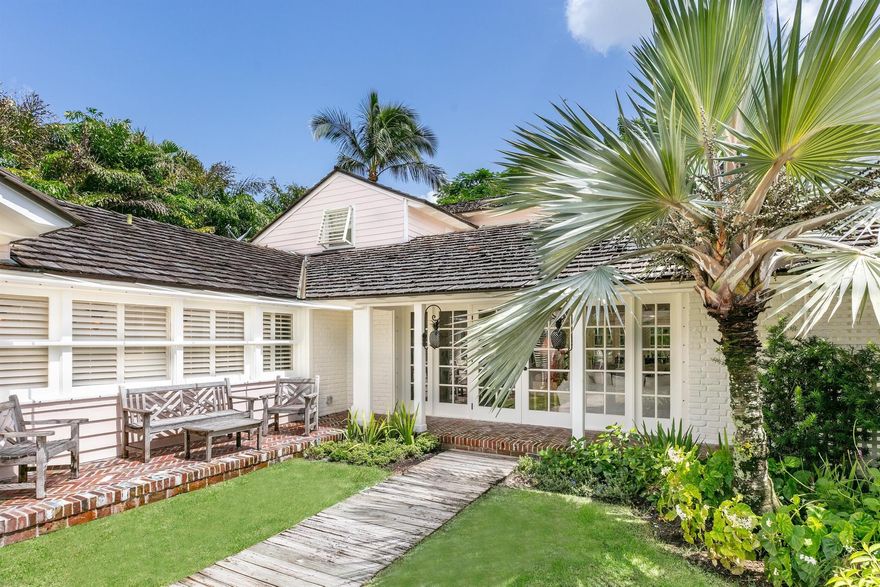 Lovely 4BR/4BA beach house. Light filled living room with vaulted beam ceiling and fireplace opens to dining area with bar. First floor primary suite with sitting room. Additional highlights include eat-in kitchen, breakfast room, and patio ideal for al-fresco dining. Beautifully maintained grounds, charming courtyard entry, and attached carport. Cedar shake roof and beautiful architectural detailing throughout. Fantastic North End location on Orange Grove Road. Beach access to the east and direct Lake Trail access at the top of the street.