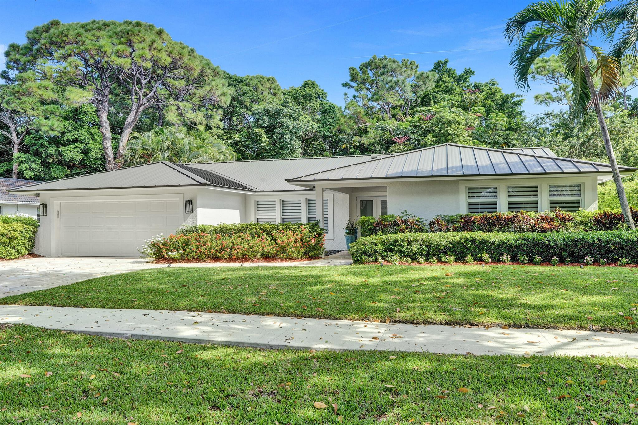 Stop daydreaming and start living the serene and tranquil lifestyle in your own private oasis in the prestigious, tree-lined enclave of Millpond, one of Boca Raton's most cherished and picturesque neighborhoods. Tucked away on a quiet cul-de-sac street, this fully renovated 4-bedroom, 2.5 bath home spans 2,370 sq. ft. and is perfectly positioned to capture sweeping views of the new sparkling saltwater pool with summer kitchen nestled against lush landscaping and a private community park.The 2025 metal roof is not just a bold design feature, but offers a 50-year lifespan, superior energy efficiency and the best insurance rates. Full-impact windows and doors provide added safety and storm protection, giving you lasting peace of mind.