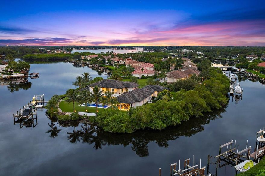 Located on a peninsula lot of 1.33 acres with 500 feet of deep waterfrontage on three sides with no fixed bridges, this truly is one of the finest waterfront properties in our area.  Custom built in 2021 by Ocean Blue Custom Homes, this signature estate in the luxury, gated community - The Islands of Jupiter, meets the demands of the most sophisticated clients.  Floor to ceiling walls of glass brings the outside in, offering a ''light and bright'' texture to a modern coastal interior palette.  Views to the pool with spa, summer kitchen with bar, dock with two lifts, professional landscaping, and expansive backyard with endless artificial turf; all define a dreamlike setting for a family retreat.  The current owner made the following additions/upgrades within the past 12 months: 24 KW generator, electric/hurricane screens, new pool resurfacing, under dock lights, all new light fixtures and ceiling fans, paint inside and out, garage storage cabinets, luxury flooring, new kitchen island counter top & back splash, bar top, primary bath counter top, and two sets of washers and dryers - one set for each floor.  The primary suite and guesthouse are on the first floor, and three guest suites plus an expansive loft area and second laundry room occupy the second floor.  Call today to view this amazing property that could be yours!