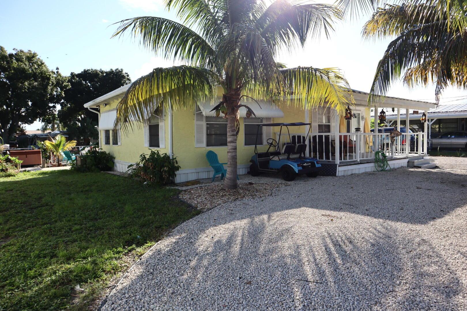 Double lot! High ceilings. Build your dream barn on the second lot! Plenty of room for your RV and you can Dock your Boat right out back! Cruise the canal spontaneously or head out to World Class Bass Fishing Capital Lake Okeechobee for a day of fishing and boating. This is a single family home and the sellers have been told it was a train depot that was moved there. The main home is built with extra thick walls, solid Dade pine, and thick concrete stucco. This home also has space for 2 more bedrooms. Large living, dining and kitchen and the guest suite has its own entrance making it ideal for multi-generational living or roommate situations. You'll love the front porch and back porch over the water. The home is priced low to accommodate the buyer's desires to update.
