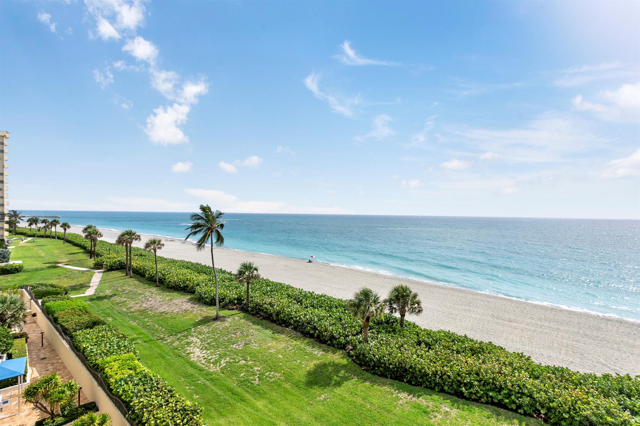 This 5th floor OCEAN END UNIT has 2 bedrooms and 2 baths and sits directly on the beach in Jupiter. Ocean end units are larger than the interior condos, and each bedroom faces due east for the best ocean view. King primary bedroom and the 2nd bedroom is a queen murphy bed. There are TVs in both bedrooms - 3 TVs in total. The oversized main balcony off the living room is shady all day with a view to the Jupiter Inlet. Amenities include heated pool and spa, sauna, fitness room, social functions, tennis with an active pro shop, gated entry, secure under building parking, and of course direct beach access. Enjoy private gate access to the Jupiter Beach Resort which is adjacent to Ocean Trail. Ocean end units are very popular, and rarely available to rent. This is the only one!