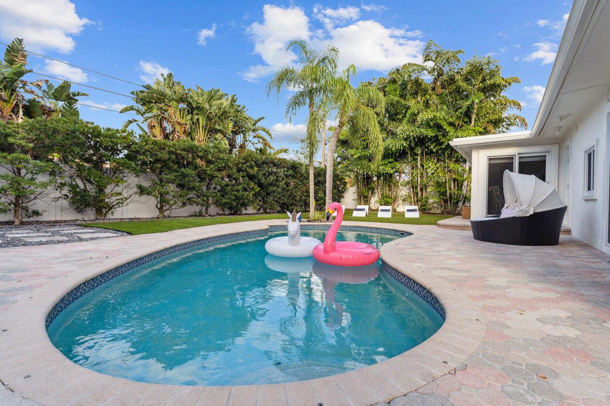 Stunning 3BR/2BA home in the prestigious Lighthouse Point! Currently an AirBnb but it can be your Dream Home. Step into a bright, open-concept great room with vaulted ceilings and views of the resort-style backyard. The chef's kitchen boasts quartz countertops, custom cabinetry, Carrara marble backsplash, stainless steel appliances, and walnut-wrapped beams. Adjacent is a Florida room with a built-in bar and oversized sliders leading to the pool and electric-wired gazebo--perfect for entertaining.Enjoy low-maintenance living with artificial turf, a fully irrigated vegetable garden, and seamless indoor-outdoor flow. The oversized primary suite features a custom dressing room/office/nursery space, spa-style bath, double vanities, large shower, and direct pool access.