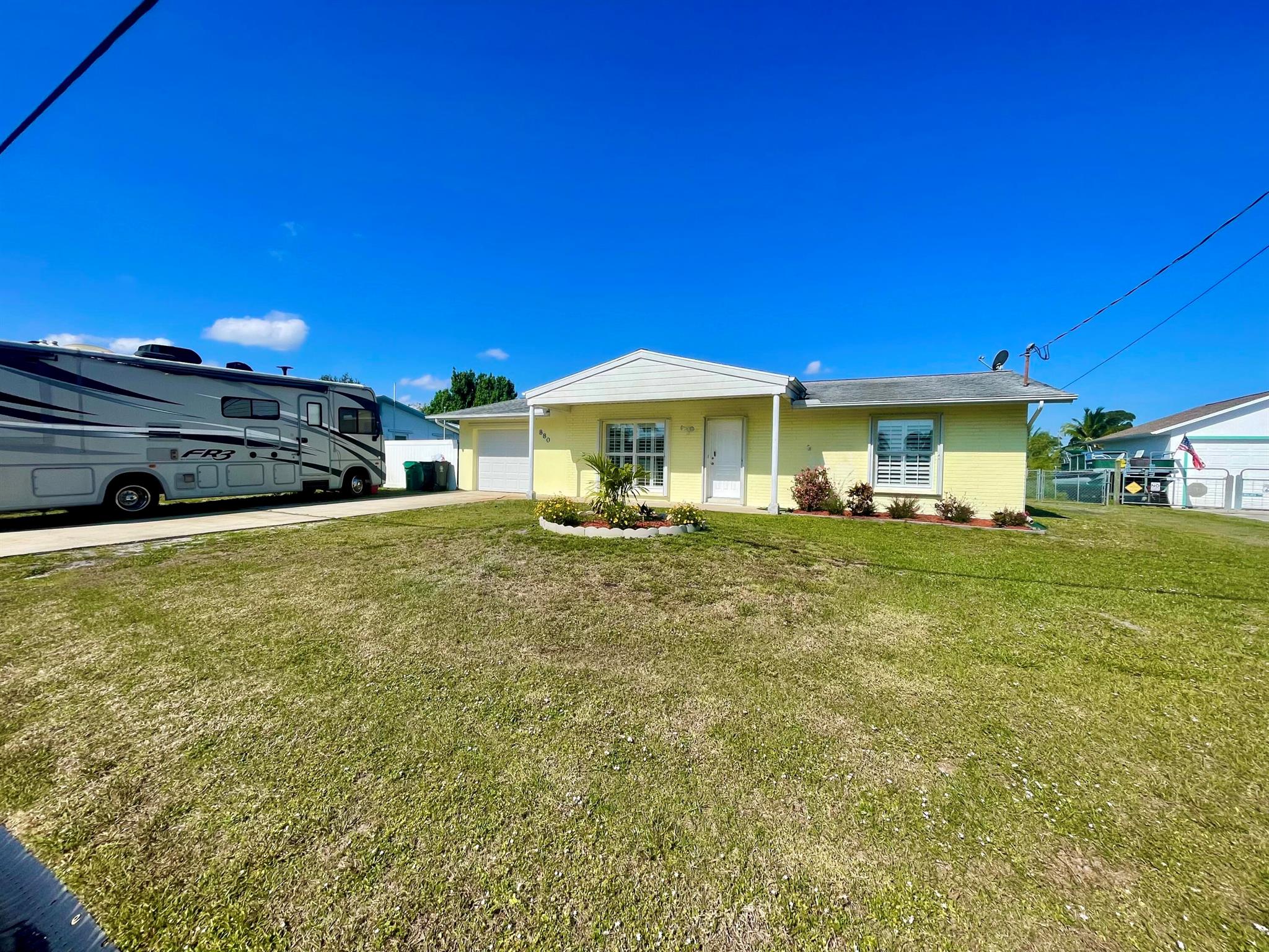 Experience Florida living at its finest with this ocean access extra-large almost 1700 SF 2 bedroom 2 bath CBS home updated to include a huge primary bath and bedroom, and extra storage shed. This tropical oasis features a formal dining room, updated kitchen with stunning blue pearl granite counter and stainless steel appliances breakfast bar, family room that leads to the inviting pool and your private dock. This home is situated on a fully fenced 1/4 acre lot with a 30 amp 125 volt RV hookup. Plenty of space for all of your toys to enjoy this luxurious waterfront lifestyle! No HOA!