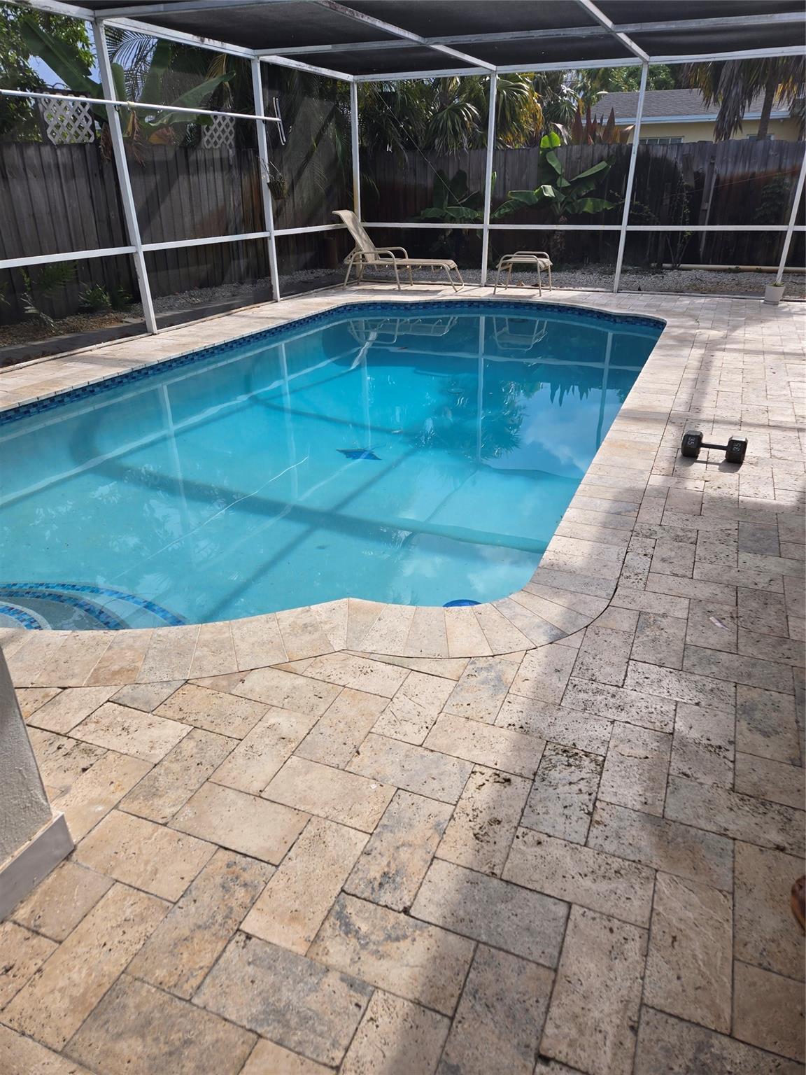 NO HOA! Welcome to this stunningly renovated 4 bedroom, 3 bathroom home! Brand-new kitchen complete with vent hood, stove top, quartz countertops, stainless steel appliances. Home features new tile flooring creating a fresh, modern feel. Outside, you'll find a private oasis with a screened pool recently diamond brite, pavers on pool deck, and a fully fenced yard, perfect for relaxing or entertaining. The bathrooms fully updated with new vanities and quartz countertops, glass shower doors. Home features solar panels, hurricane rated 2025 garage door with epoxy garage floors , tankless water heater, landscape lighting. House is wired for speaker. Property is fruited with avocado, coconuts, ackee, apple and mango. Move in ready!
