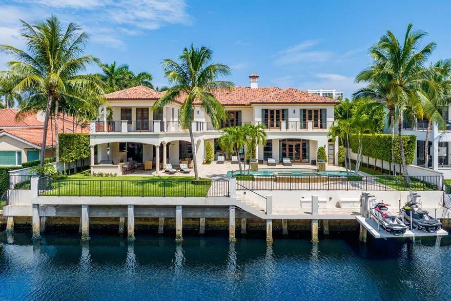 Located in one of the most coveted waterfront sections of Royal Palm Yacht & Country Club, this five-bedroom custom residence built by SRD Building Corp is in pristine condition, providing a like-new feel. This beautiful home is offered fully furnished & turnkey with luxurious furnishings throughout. With over 10,000 total sq ft, the estate features an open floor plan; 4-bay garage; chef's kitchen; club room with theater; dedicated study; integrated smart-home Crestron system, Vantage lighting; 70kw generator; large elevator; spacious primary suite with morning bar, dual baths & closets, impact doors & windows, full of natural light.  The resort-style backyard features an expansive covered loggia; pool & spa; summer kitchen; large turf yard, 100' of waterfrontage and dock.