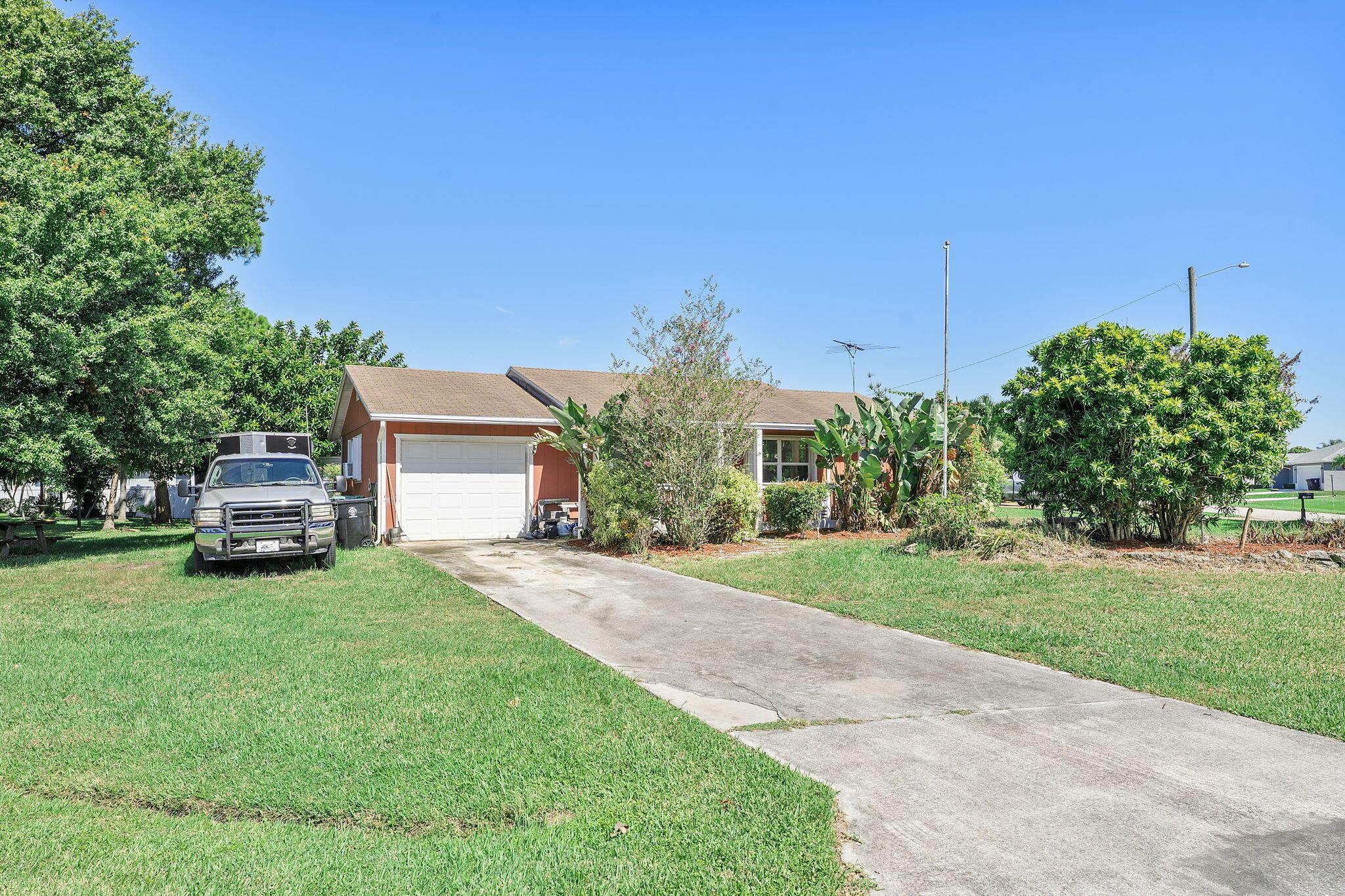 Welcome to this beautiful 3-bedroom, 2-bathroom single-story home in a peaceful Port St. Lucie neighborhood. This inviting property offers a wonderful blend of traditional charm with contemporary updates that today's buyers are looking for.Inside, you'll discover an open-concept living and dining area with attractive laminate wood flooring, recessed lighting, and a ceiling fan. The kitchen has cherry wood cabinetry, marble-look countertops, a stainless steel sink, and white appliances - creating a functional space for both everyday meals and entertaining guests.