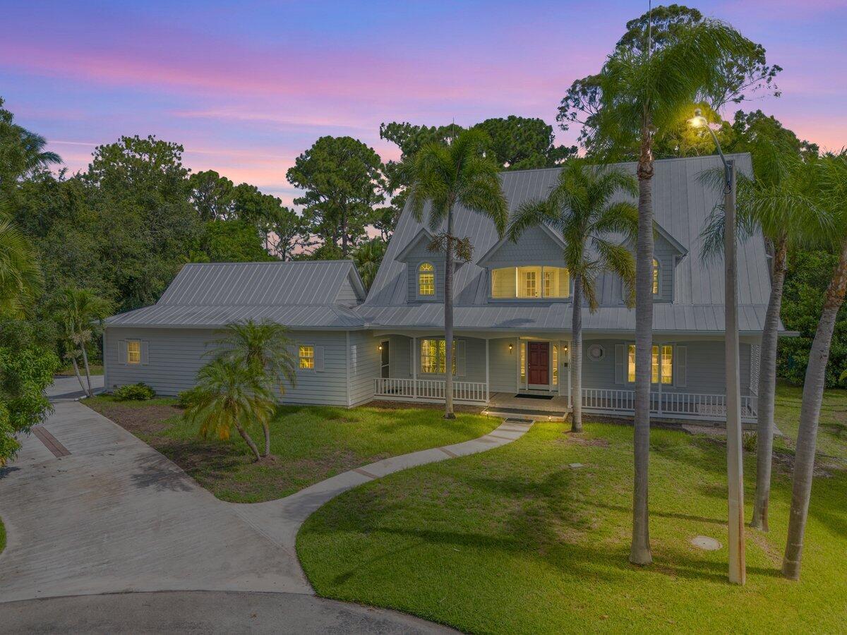 A rare Southern-inspired gem in Sandpiper Bay's peaceful riverfront enclave; Kitching Cove Estates. This two-story home delivers timeless charm and big-ticket value. Enjoy a deeded private dock + lift with direct access to Stuart Inlet; no fixed bridges. With a metal roof (2011), 3 HVACs, 2 water heaters, and a .57-acre cul-de-sac lot backing to preserve, this home offers flexibility, privacy, and serious potential. Nearly 2,900 sqft with 3 bedrooms, 4 full bathrooms, a distinguished staircase, wraparound porch, and a back screened lanai overlooking the preserve. Inside, you'll find graciously oversized living area overflowing with natural light filtering through dormer & arched windows that adds warmth and character. The extra-large upstairs primary suite offers a spacious retreat with