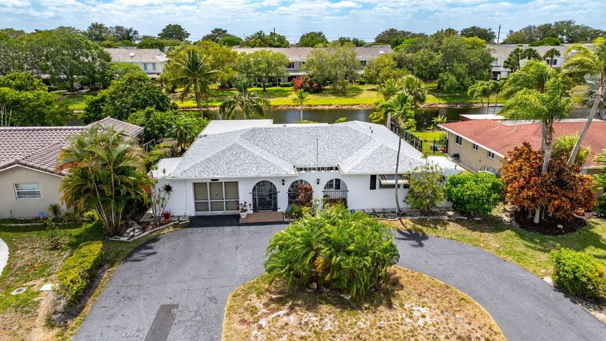 Enjoy this spacious, pretty home on a beautiful waterfront lot in the most sought after family community in West Tamarac! Circular driveway, Roof installed 2023, AC replaced 2022! Enjoy the light & bright living room with built-in shelving & custom wood shutters. Formal dining room-very inviting for your family & friends to sit & stay a while! Upgraded eat-in kitchen-nice cabinets, counters & large sink. Great pantry too! Family room/home office can easily be used as a 3rd bedroom if needed. Enjoy the serene, super sized main bedroom suite-walk-in closet, wooden shutters with dynamite water views & spacious bathroom. Second bedroom is surprisingly large-has great closet space! WOW-covered screened patio & special cement patio leading to the canal. This is the Florida lifestyle you deserve! Special home features to make your organization a breeze-the garage has an additional utility room/storage area you just have to see! This space is in addition to the one car garage. There is also a very nice laundry room with a utility sink and storage. Also on the opposite side of the home is a custom, built-in garden storage shed/area. Community and location features -the community has a clubhouse and pool!The home is located near a beautiful City of Tamarac walking/exercise park and a doggie park as well. It is not too far from the Coral Square mall, great shopping, restaurants, banking, doctors offices.  The City of Tamarac has a wonderful community center with lots of activities for its' residents and right next door is a very cool Broward County library with 50 public computers, a quiet study room, 3 tutoring rooms and a young adult area!Come see this home today!