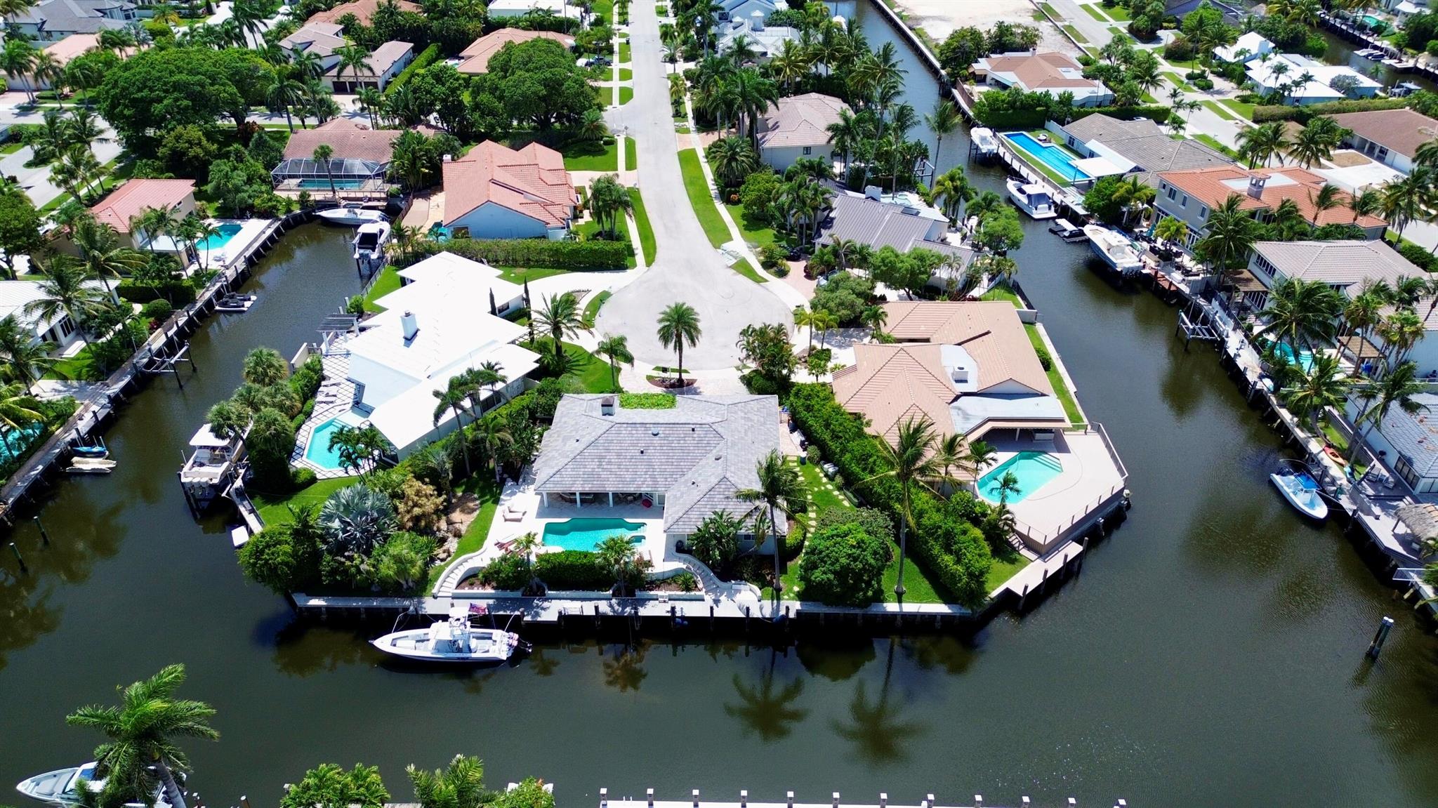 EXCEPTIONAL EAST BOCA RATON HOME WITH 180' OF STRAIGHT WATERFRONT WITH DEEP WATER ACCESS & NO FIXED BRIDGES! Perched at the end of a cul de sac peninsula, this coastal stunner is highlighted by a massive 100 foot dock (2015) capable of housing a fleet of boats! Complete impact windows & doors (2014), concrete tile roof (2014) & a massive 13,500 sq foot lot make this property a stunning South Florida value. Step into coastal breezes & island serenity perched above the water. Ideally located between downtown Boca Raton & Atlantic Avenue, Boca Bay Colony is quickly and quietly becoming a premier east Boca Raton boating destination. With newly-built custom estates, easy ocean access, massive lots, wide streets & buried power lines, see why this neighborhood is the secret no one knows about!