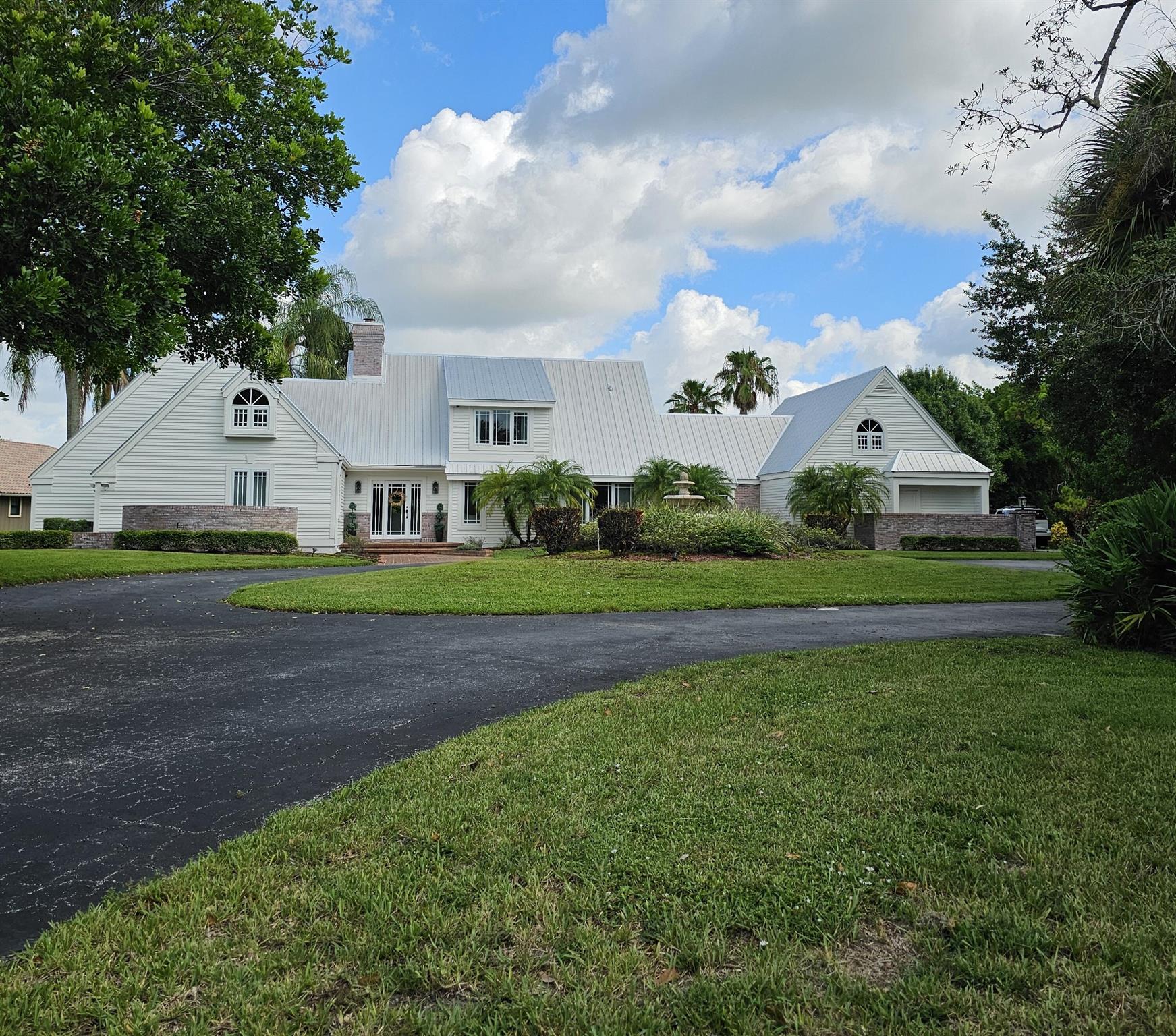 Welcome to one of Palm City's most charming Estate homes located on the golf course on over an acre in the securely gated community of Martin Downs Country Club. This timeless Cape Cod Victorian residents blends classic character with modern upgrades. Also, two of the four bedrooms are Masters. Maximizing privacy with a four-way bedroom split design. All four have their own bathrooms, in addition there is a guest powder room.