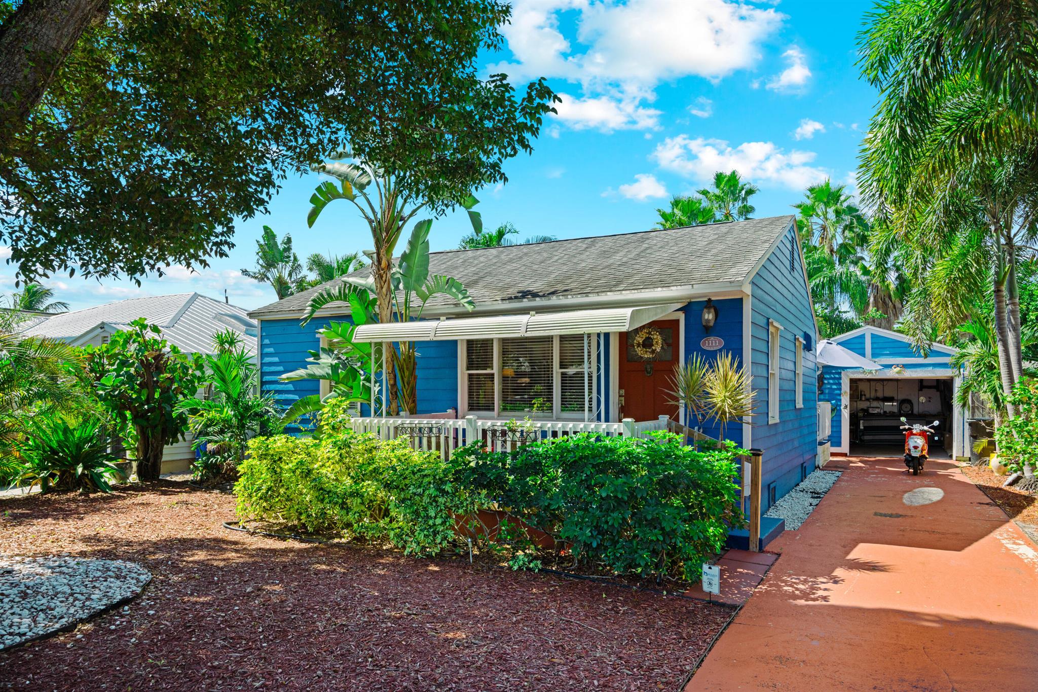 Twice featured in the Cottages of Lake Worth Tour, this is THE quintessential Lake Worth Beach cottage and you could be the next proud owner! This charming coastal cottage offers 2 bedrooms, 1 bathroom, and a spacious eat-in kitchen, but the real gem is the backyard! Step into a private tropical oasis with mature palms, hibiscus, and more. Enjoy the deck and gazebo--perfect for relaxing, entertaining, or watching sunsets. The home also has a detached one-car garage with plumbing and power, long driveway, covered porch, and a quiet location near downtown, the golf course, the beach, and PBI Airport.