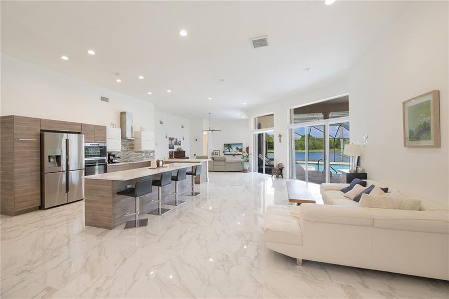 Welcome to this beautifully renovated home in prestigious Weston Hills Country Club. A two golf course community. Features 5 bedrooms, 3 full baths, screened-in pool area on peaceful lake. Luxury living at it's best! Modern open kitchen with state of the art appliances (induction cooktop), huge island with quartz countertops, two tone cabinets, large porcelain tile floors throughout living area, hardwood floors in all bedrooms. All bathrooms have been remodeled. LED high-hats, 2015 Roof, accordion shutters and convenient Tesla charger in the garage. Sprinkler system utilizes water from the lake. Gated community with close access to I-75.