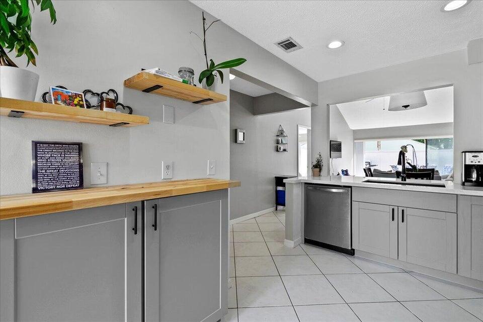 Fully furnished seasonal rental! This charming 3-bedroom, 2-bath townhouse is the perfect retreat for your winter stay. The open floorplan features vaulted ceilings and an abundance of natural light, creating a bright and airy atmosphere. A beautifully remodeled kitchen, tile throughout and sliding doors from each bedroom and the living area open to the outside. Enjoy complete privacy with an enclosed front courtyard and a fully fenced backyard, ideal for outdoor dining, grilling, and relaxing with friends. The community has plenty of grassy common areas and a community pool with serene lake views. Conveniently located within walking distance to several restaurants, and just a short drive to both Global and Wellington International.
