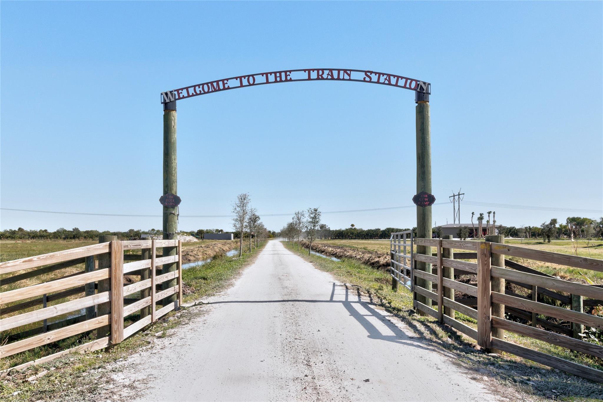 125 Acres: Cleared agricultural site, fully fenced, development ready. 2,329 sq. ft. Hunting lodge premium craftsmanship, millwork, walnut crown, repurposed pine, hickory floors. Off-Grid & independent with generator & solar power systems. Two ponds, One is 35-ft deep. 30x80 CBS pole barn with three 20-ft roll-up bay doors, perfect for equipment storage. Close to the St. Lucie County Fairgrounds. Situated along State Road 70. Potential for zoning change, alignins growth trends. Adjacent to 3,300 acres recently rezoned for development of Oak Ridge Ranches, plans for 8,600 homes. Within 1.5 mile of newly approved 663-acre P-1 Motorsports Complex, attracting high-end clientele. Prime access to future high-net-worth residents and clients drawn by motorsports complex, fairgrounds.
