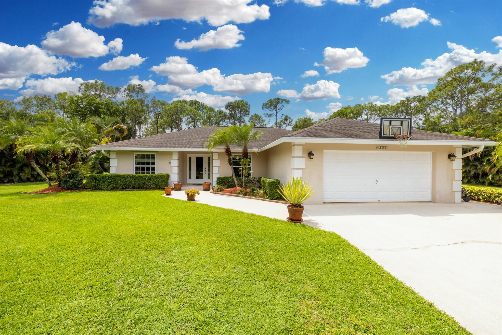 Welcome to this extremely well cared for and maintained 4-bedroom, 2-bath home on an oversized 1.15-acre lot in the desirable community of The Acreage. Designed with an open floor plan, split bedrooms, and vaulted ceilings, the home offers comfort and functionality. Inside, you'll find carpet and tile throughout the main living areas, a kitchen with stainless steel appliances, newer countertops, and a dining space perfect for entertaining. Updates include all double-hung insulated low-E windows with screens, a premium roof with 130-mph rated shingles and lifetime warranty (2013), Rheem 4-ton 3-stage A/C with EcoNet SmartHome and 10-year warranty (2024), Bosch Silence Plus dishwasher (2024), Samsung MultiSteam dryer (2025), and a newer (2019)