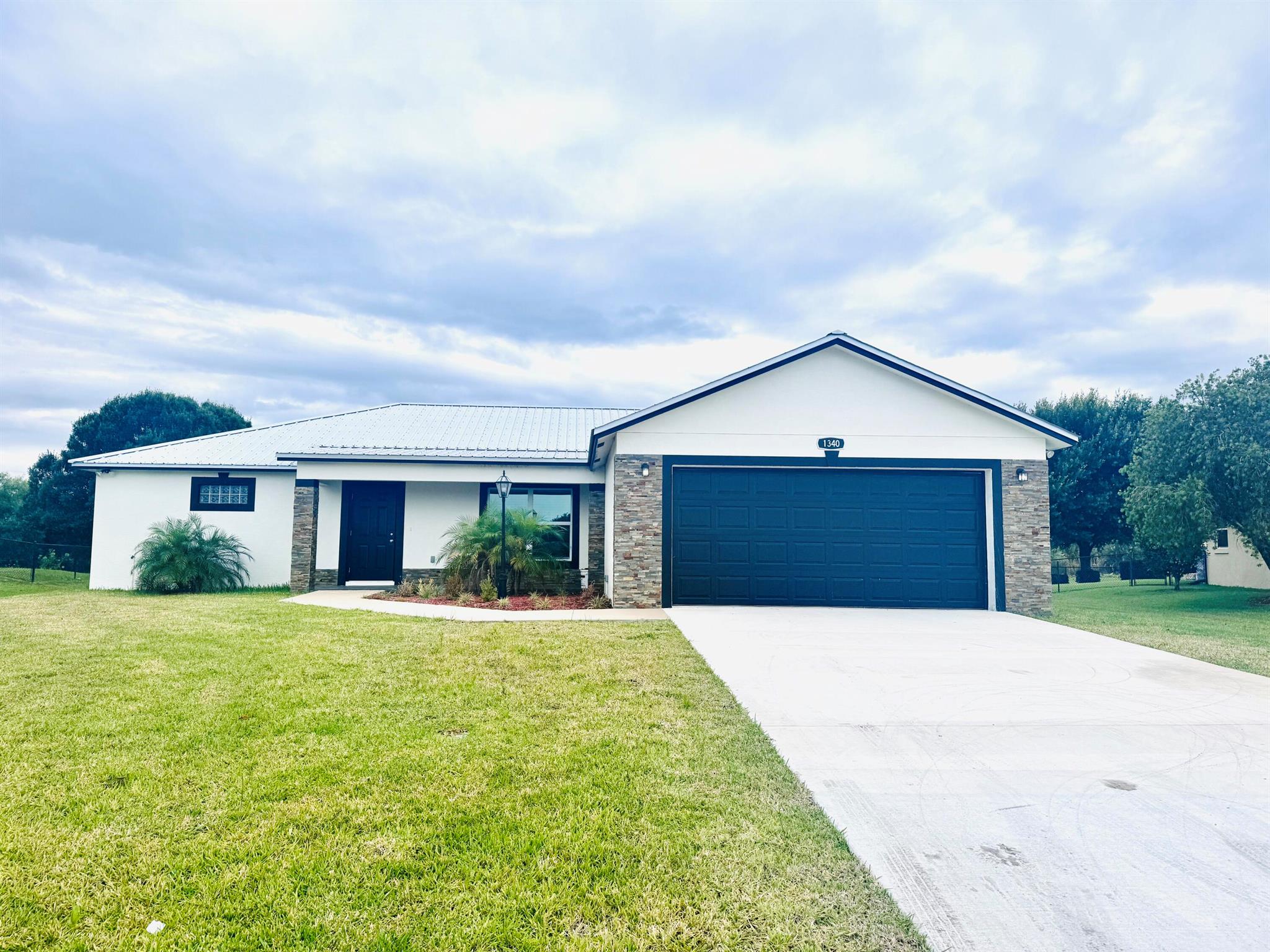 New construction- 3 bed, 2 bath CBS home with 2 car garage in a beautiful neighborhood close to town! Features include a metal roof, custom stonework on front of home,large open concept layout & window blinds already in place! The kitchen has quartz countertops, stainless steel appliances, a kitchen island & a large pantry with pull out shelves. The master bedroom has large walk-in closets, and the master bathroom has his/hers sinks and a luxurious oversized walk in tiled shower. Enjoy added value with an included washer and dryer and upgraded septic system. Concrete patio area in back of home is ready for a porch addition. Move in ready and build to impress - don't miss this one!