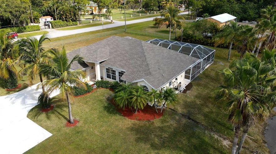 Look no further...country living in this 3BE  pool home on 1.42 acre corner lot on paved roads in the desired Acreage/WPB area.Brand new roof & hurricane panels*Open kitchen with new corian countertop*Vaulted ceiling*Formal dining area*Beautifully updated master BA  & partially redone guest BA*All tiles in diagonal in living space & pergo in BEs*Absolutely amazing patio perfect for entertainment-spacious covered area,screened in pool & spa with waterfall*Relax by the pool or by the pond with a splash of the fountain & observe fish,turtle & birds around!Fully fenced,new pool & sprinkler pumps,new well.This is a formal builder model with a ton of upgrades-automated windows treatment,all lights on remote control,extra insulation,speakers & prewired for SAVANT home system.NO HOA!Come & see it!