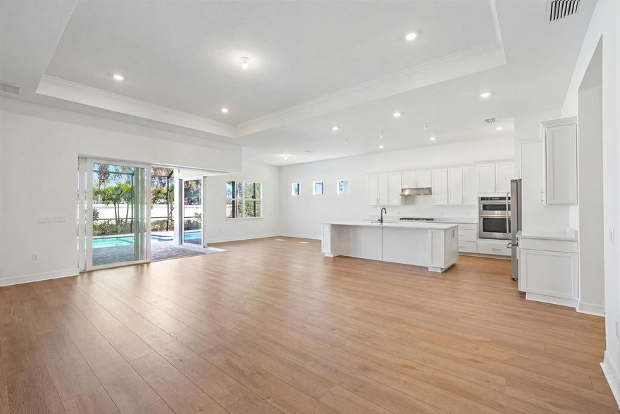 Set within the sought-after Avondale neighborhood of Avenir in Palm Beach Gardens, this exceptional Stellar model from the Estate Collection blends modern design, thoughtful upgrades, and effortless indoor-outdoor living. Offering 3 bedrooms, 4 full baths, and 2,523 square feet, this beautifully enhanced residence is positioned on a .23-acre estate lot with a desirable coastal exterior and a true three-car garage featuring a rare 4-foot extension. From the moment you enter, the home's light-filled layout and refined finishes make an immediate impression. A dramatic zero-corner sliding glass door in the gathering room creates seamless connectivity to the lanai, blurring the lines between interior and exterior living. Luxury vinyl plank flooring flows throughout all living areas, complemented by upgraded LED lighting and a curated four-light downlight package in the gathering room and owner's suite.
The kitchen is both elevated and functional, showcasing upgraded cabinetry, 1.2" quartz countertops, pendant pre-wiring, and a layout designed for gathering. Technology and convenience are thoughtfully integrated with a Smart Home low-voltage package, wireless access points, a 16-port network switch, flat-panel TV prep with LAN wiring in all bedrooms and gathering areas, and custom TV mounts.
Each bath has been tastefully enhanced. The owner's suite features a spa-inspired bath with a walk-in shower and soaking tub, heavy frameless glass enclosure, dual shower heads, upgraded countertops, fixtures, and custom mirrors. Secondary baths also offer walk-in showers with frameless glass, upgraded finishes, and custom detailing. A dedicated lanai bath with walk-in shower adds convenience for poolside entertaining.

Step outside to your private retreat--highlighted by a 14' x 30' custom pool with screen enclosure, gas line stub-out at the lanai, and generous covered space designed for year-round enjoyment. The backyard setting provides both privacy and the perfect backdrop for relaxed Florida living.

Additional upgrades include an advanced HVAC air quality system with Carbon Clean MERV 16 filter, UVA light, and catalyst, a full laundry room with upgraded cabinetry and sink, a complete security system with three wired outdoor cameras and integrated video doorbell, and a meticulously finished garage with custom epoxy flooring, additional lighting, keyless entry, GFI circuit, sink, and LED enhancements.

Avondale at Avenir offers a vibrant, amenity-rich lifestyle with resort-style pools, fitness facilities, walking trails, and the future Town Center bringing dining and shopping moments away. Surrounded by preserved green space yet close to everything Palm Beach Gardens has to offer, this residence represents refined, move-in-ready living in one of South Florida's most dynamic new communities.