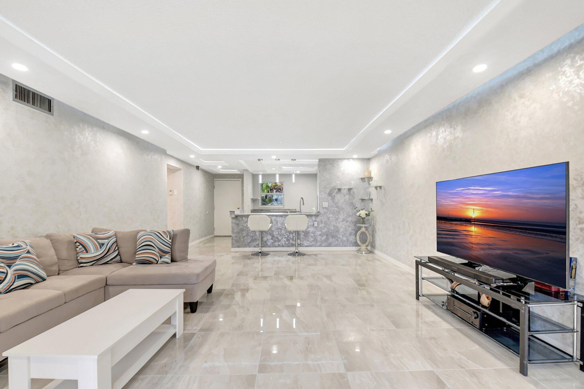 Stunningly renovated 2-bedroom, 2-bathroom corner unit. Priced to sell in this active 55+ community, this spacious condo is bright and airy. Inside, you'll find a modern, open-concept kitchen with sleek white cabinetry, new appliances, and gleaming porcelain floors. Freshly painted Venetian walls and a drop-down ceiling with new LED lighting create a sophisticated atmosphere in the living space. Both bathrooms have been completely updated with new porcelain floors and modern glass sliding doors. The unit also features hurricane-impact windows, a screened-in porch, and central AC and heating for comfort and security. The monthly HOA fee includes water, cable, and building insurance, and the community offers a wide range of amenities: pools, Pickleball, fitness, active clubhouse Etc