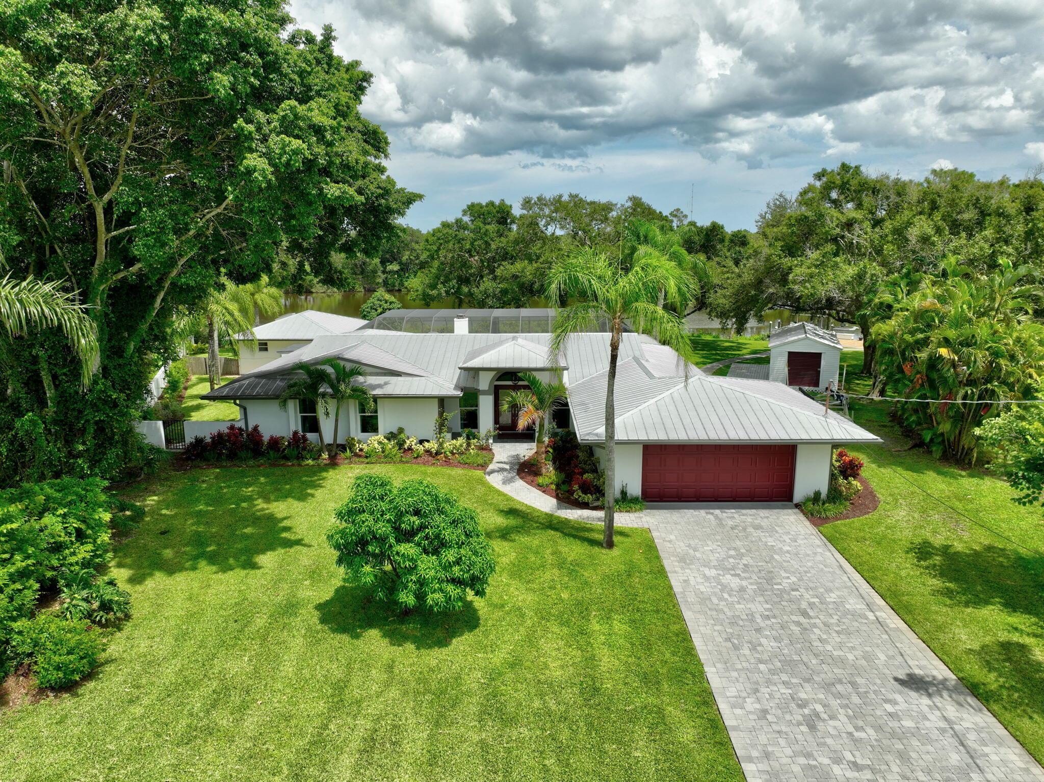 OCEAN ACCESS!! Situated on the St Lucie River with stunning views! Home sits on .7 of an acre (oversize lot) with approximately 240+/- ft of water frontage and is a true boaters or fisherman's dream! 2020 Boat lift installed w/capacity to hold 16,000 with a tackle shed! Enjoy this 4 bedroom 3 bath home with open floor plan in which the primary bedroom overlooks the pool and river. Entertaining your guests along side the screened in pool. New flooring thorough out home and updated kitchen. Features detached newly renovated in law suite with private entrance, kitchenette, full bathroom and stunning views of the river and pool. Excellent rental income as a private quarters or lovely guest suite. HOME COMES FURNISHED W/ BOAT AND BUICK SUV low mileage.