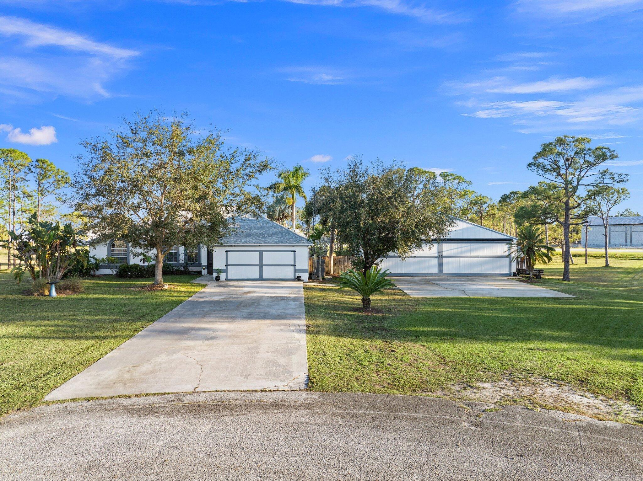 Discover this exceptional 3-bedroom, 2-bathroom custom-built home situated on 2.76 acres AG-5 zoned lot, offering ample space and endless possibilities in the prestigious Treasure Coast Airpark (FL 37). This unique property presents a rare chance to own a hangar home adjacent to one of South Florida's longest hard-surfaced runways. The newly constructed 4,000-foot private, lighted asphalt runway can accommodate aircraft up to 12,500 pounds, with direct access via a grass taxiway leading straight to your hangar.Aviation enthusiasts will love the detached hangar featuring a hydraulic swing door (50x50x10), capable of accommodating an airplane with a 40-foot wingspan. The hangar also includes a shed, ideal for tools or a workshop. Practical upgrades include a new roof (2023) on both