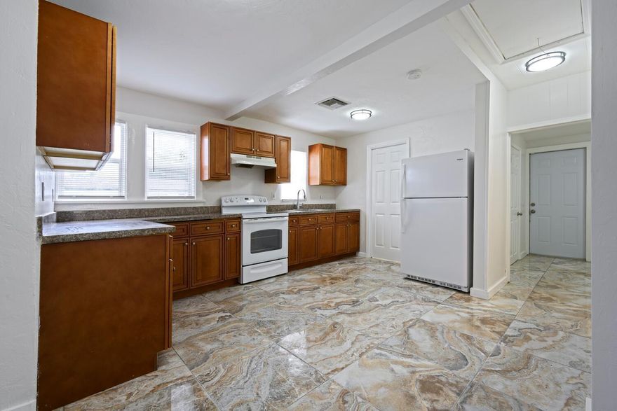 Discover this beautifully updated 4-bedroom, 2-bath Key West style home nestled on a generous 50' x 135' corner lot in the desirable Whispering Palms neighborhood. Remodeled with permit in 2016, this light-filled home features an open-concept kitchen with custom cabinetry, granite countertops, and newer appliances--perfect for entertaining or everyday living. Enjoy elegant porcelain tile flooring throughout, fully renovated bathrooms, and a spacious, dedicated laundry room. Updated windows/doors in 2015, offering peace of mind and energy efficiency. Dec. 2023 shingle roof, and the home comes with a 2025 termite treatment and warranty. Dual driveways and a detached carport, plus a boat/RV pad. This move-in ready gem offers the perfect blend of comfort, convenience, and coastal charm.