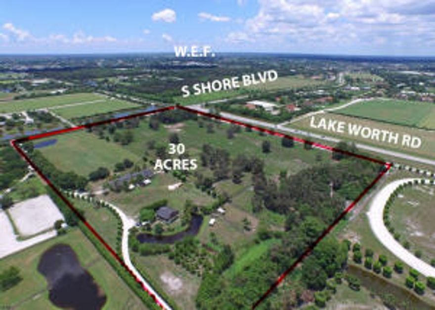 30 ACRES in Wellington!! Great opportunity to purchase a property at the corner of SS BLVD + Lake Worth Rd. Close to all equestrian venues. 16 stalls (12x12) center isle barn, 2 apartments with paved Rd. Prime land to build your dream barn.