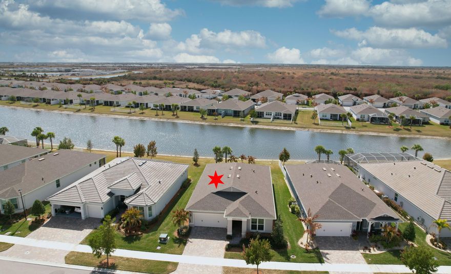 Gorgeous 2023-built Palmary model on a serene water lot! This light and airy home features a wide-open floor plan designed for comfortable living and entertaining. The spacious kitchen offers a large island, abundant soft-close cabinetry with pull-out shelving, and an oversized walk-in pantry. Tile flooring runs throughout the entire home for a clean, cohesive look. A versatile flex room with French doors is perfect for a home office, den, or hobby space. The beautiful owner's suite includes a large walk-in closet, dual sinks, and an easy step-in shower. Enjoy peaceful water views and the benefits of newer construction in this thoughtfully designed home. Active 55+ community with 2 clubhouses, 2 pools, pickleball,tennis, bocce, putting green.