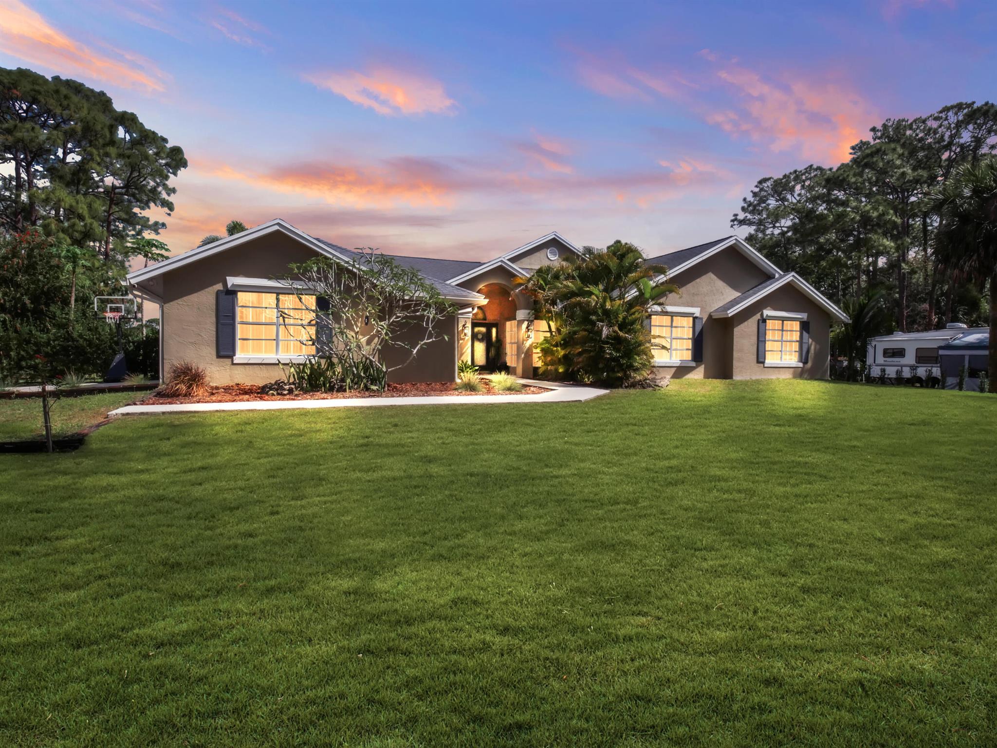 Modern 4-Bedroom, 3-Bath Home with Pool, RV Income Potential, Tropical Landscaping on 1.15 Acres in Loxahatchee Step into the refined essence of Florida living. This fully renovated 4-bedroom, 3-bathroom residence sits on a lushly landscaped 1.15-acre lot in one of Loxahatchee's most desirable neighborhoods. Combining modern comfort with elegant style, this turnkey home is ready for move-in. Interior Features An open-concept layout welcomes you with spacious living areas, stylish design details, and abundant natural light. Premium porcelain tile and laminate flooring flow throughout the home, while custom closet doors and sleek finishes elevate its modern character. The stunning kitchen features chic cabinetry, updated fixtures, and a layout perfect for both everyday living.