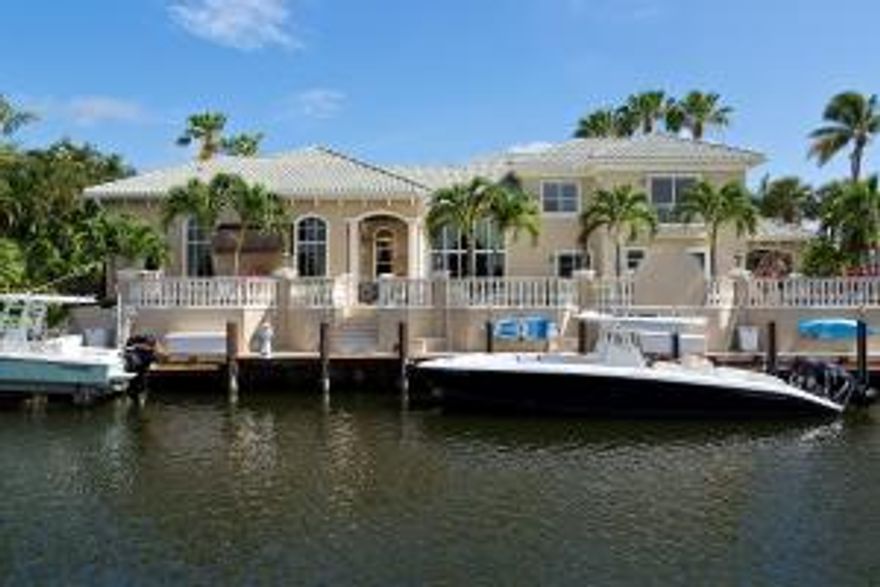 This stunning 5,880 sq ft Boca Bay Colony waterfront estate home has the perfect balance of indoor and outdoor resort lifestyle features, has been recently remodeled with the highest quality fixtures, has a desirable southern exposure, 150' of waterfront on a deep water canal, and can accompany multiple boats up to 80'. The backyard is expansive and private as it sits 12' higher than the water and is protected by balusters and tropical landscaping. This home is move in ready as the renovation has given tremendous attention to detail throughout the entire property. This 5 bedroom home has all impact glass, high ceilings, brand new kitchen, private office, 140' new dock with room for multiple boats, outstanding backyard designed for entertaining, master bedroom is located on the second floor