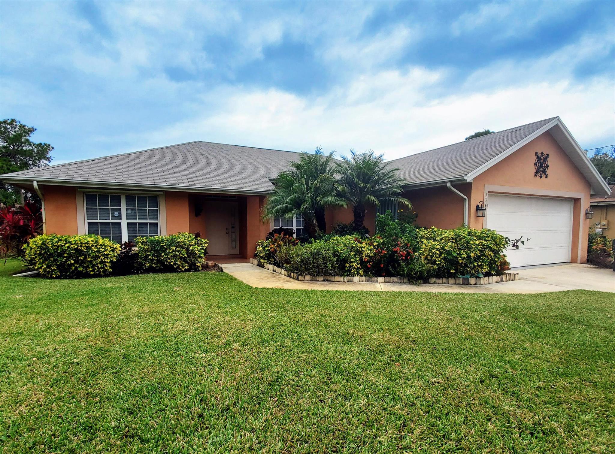 This charming 3-bedroom, 2-bath, 2-car garage CBS block home offers a perfect blend of comfort, style, and location. Featuring a brand-new roof and durable tile flooring throughout, this home is move-in ready and built to last.Step into a bright and updated kitchen complete with granite countertops, white shaker cabinetry, and a striking tile backsplash. The split-bedroom floor plan provides privacy, while the spacious covered and screened-in patio is ideal for relaxing or entertaining year-round.Outside, enjoy lush tropical landscaping that adds beauty and curb appeal. With easy access to both the Turnpike and I-95, you're just minutes from shopping, dining, schools, and the Mets Spring Training Stadium. Don't miss this centrally located Port Saint Lucie gem!