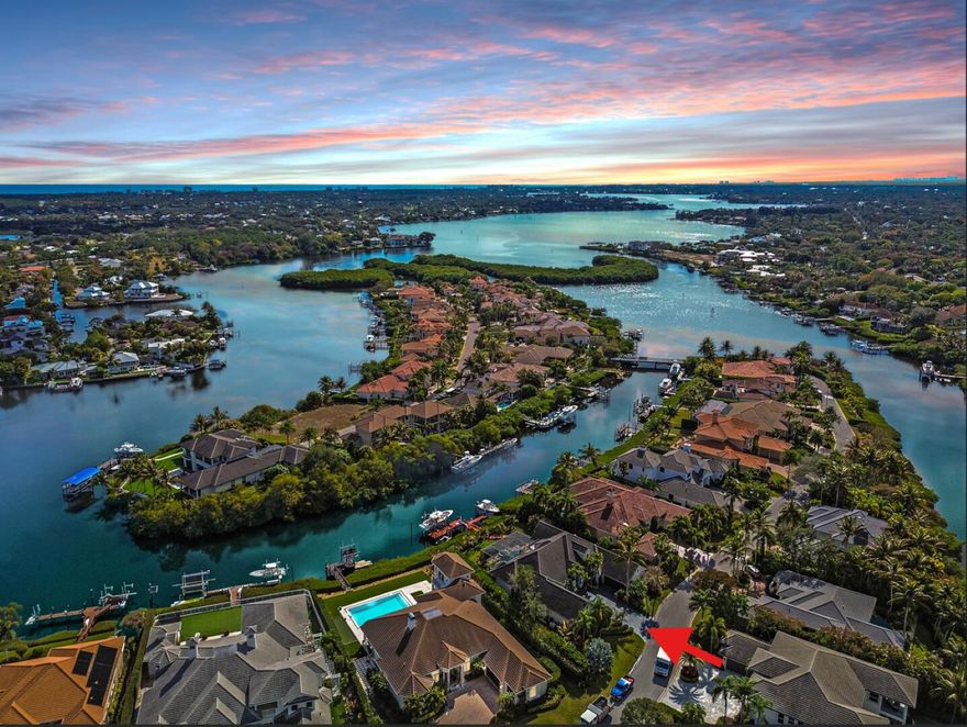 No Fixed Bridges, Ocean Access. The waterfront lifestyle in the prestigious Islands of Jupiter gated community. This 4,648 SF open split floor plan with 4 bedrooms and 5 en-suite baths, a bonus room, and two oversized 2-car garages. The main level features the primary suite and two guest rooms, plus an upstairs VIP suite with a sitting area, wet bar, and private balcony with river views. Enjoy 100' of waterfront, direct ocean access in ~10 minutes with no fixed bridges, and a private dock for 2-3 boats. Outdoor living includes a pool, spa, cabana bath, outdoor kitchen, and screened patio. Recent upgrades include a new roof, kitchen, paint, porcelain-paver driveway, and impact windows/doors. A fenced yard, full-house generator, and whole-home water system complete this move-in-ready retrea