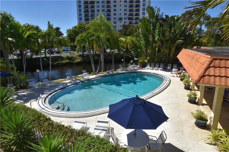 2nd floor corner one bedroom unit in pleasant building located within view of pool area. NEW impact windows. Fresh neutral paint top to bottom with brand new blinds, NEW frosted glass doors and a NEW front door. So many improvements it's a must see. Neutral tile flooring, recessed lighting, gorgeous custom kitchen with stainless steel kitchen-aid appliances, granite countertops, and pantry. Large walk-in closet with extra storage room space. Spotless laundry on each floor. Picturesque pool with serene canal views. One assigned parking space close to unit.  Ez to show!