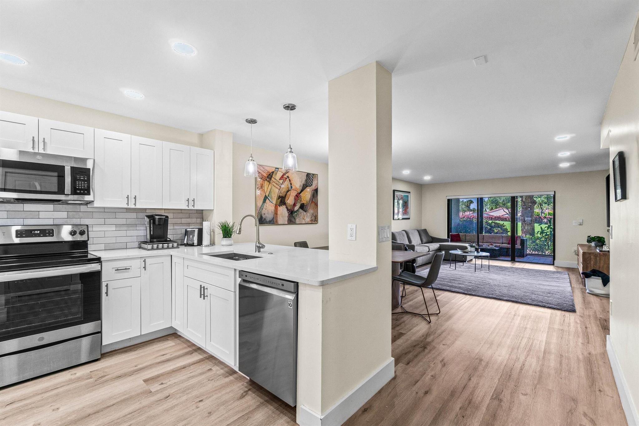NEW ON THE MARKET - Fully renovated 1st floor 2BR/2BA condo with sweeping views of the golf course. Located in the prestigious Hunters Run Country Club. Designed in a fresh, modern palette with an open-concept layout. The open kitchen shines with white cabinetry, sleek quartz countertops, and a spacious breakfast bar. Other touches include crisp, modern bathrooms, custom LED lighting, luxury vinyl flooring, several closets including a custom walk-in, remote-controlled blinds, and a lanai with floor-to-ceiling sliders overlooking the fairway. Contemporary furnishings are negotiable separately, offering a move-in-ready option. Space is available on the side of the building to add a golf cart pad with electric hook-up. Mandatory annual membership. Country club living awaits!