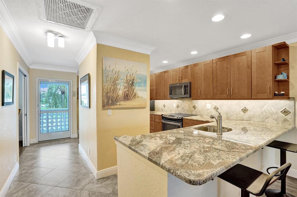 Pines of Delray Luxury Renovation! SIW HURRICANE IMPACT WINDOWS throughout; textured walls /ceilings throughout with 6'' crown molding and 6'' baseboards; 18'' Seville porcelain tile (on the diagonal) in kitchen-hallway-master dressing area-bathrooms; Burlewood laminate flooring in living room/dining area and bedrooms; Heston 100% real wood cabinetry in OPEN KITCHEN w/Netuno Bordeaux granite at counter tops; tile back splash; Solarius granite at 78'' long master dual sink vanity; Tarsus porcelain tile bathroom walls; 2017: 2.5 ton-14 seer, ac condenser & handler; all ac duct work replaced; Hydrojet water heater. 2015: 21.9 cu.ft. counter-depth refrigerator; convection range with microwave; stainless steel interior dishwasher; full size washer & dryer, custom blinds and paddle fans.