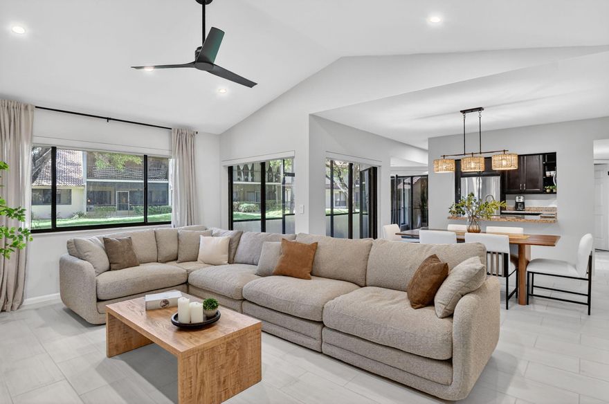 Set beneath the canopy of a mature banyan tree, this updated 2-bedroom, 2-bath first-floor corner condo with a private garage offers a rare sense of privacy in the highly sought-after Coach Houses of Town Place. Inside, vaulted ceilings and a light-filled open layout create an inviting living space, enhanced by a full interior repaint and extensive recessed LED lighting, giving the home a bright, clean, and modern feel. The kitchen features natural wood cabinetry, granite countertops, and stainless steel appliances, blending warmth and functionality while opening seamlessly to the main living area. Sliding glass doors lead to a spacious screened-in patio overlooking lush green space and the banyan tree, creating a peaceful, private setting and true indoor-outdoor living.   The spacious primary suite offers direct patio access, while the second bedroom and full bath provide flexible space for guests or a home office. Recent improvements include a fully serviced HVAC system, a 2025 water heater, new roller shades installed throughout every room, newly installed recessed LED lighting throughout, a new LG washer and dryer, an epoxy-coated garage floor, an ADT security system with control panel, door and window sensors, and a smoke detector, and updated ceiling fans. Located within a quiet cul-de-sac, residents enjoy tree-lined streets, scenic lake views, a lakeside dock, and resort-style pool amenities, all just minutes from Town Center at Boca Raton, dining, beaches, and I-95. Move-in ready with meaningful upgrades already completed, offering comfort, privacy, and low-maintenance living in a prime Boca Raton location.