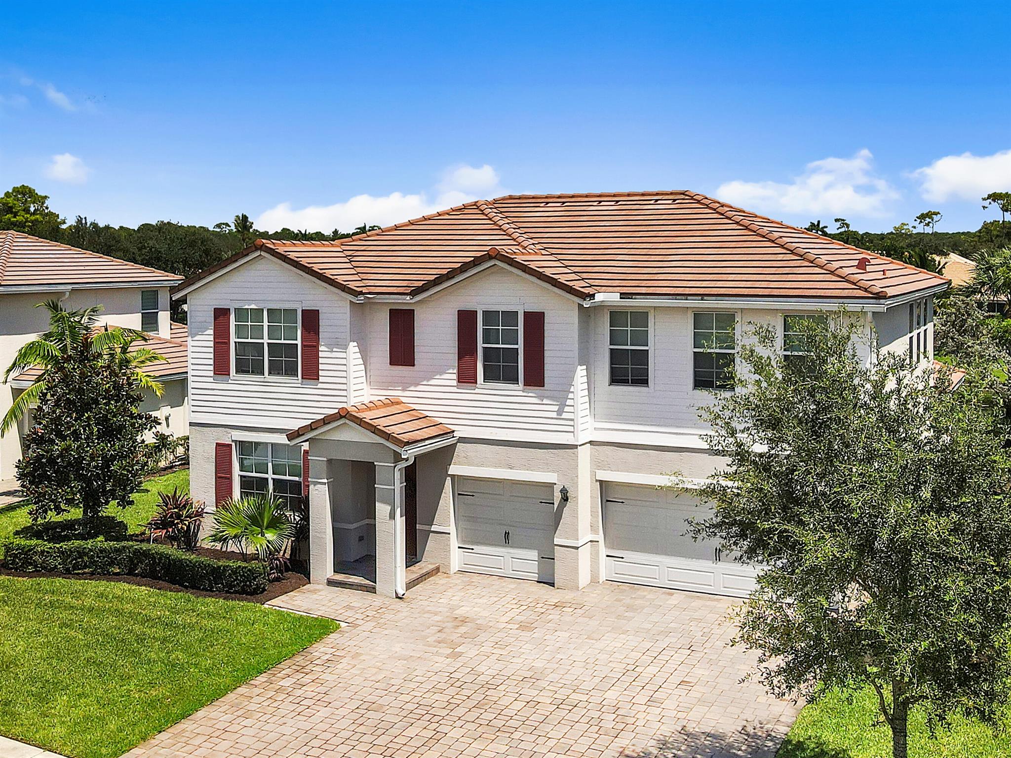Fall in love with this waterfront gem--built in 2018 and loaded with high-end finishes throughout! This multi generational 5-bedroom, 3.5-bath plus office and large loft single-family home is designed for both comfort and style, featuring an open, light-filled layout and impact windows for year-round peace of mind. The spacious primary suite is conveniently located on the first floor, offering privacy and easy access without stairs. Upstairs, you'll find an oversized loft, additional master and bedrooms perfect for family, guests, or a home office. The kitchen and living areas shine with modern touches. Tesla car charger included. Enjoy the fruit trees along with resort-style living with access to a beautiful clubhouse, pool, and gym. Centrally located near shopping, dining, PBI, WEC, Polo