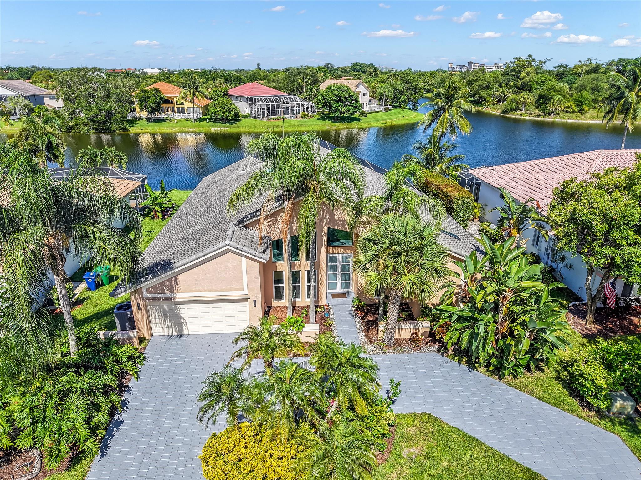 Step into this fully renovated home on lake with sleek new flooring throughout and soaring ceilings for a modern feel. The heart of the home is the chef’s kitchen, thoughtfully designed with quartz countertops, 42" solid wood cabinets, and top-of-the-line appliances installed in 2022. Bathrooms have been fully renovated with designer touches. Highlights include 2 new A/C units with upgraded ductwork, water heater replaced in 2020. Nest system, hurricane impact windows and doors throughout, and a new garage door system. New roof installed in 2021. Heated saltwater pool, internet-managed electric pool pump, outdoor shower, and all-new screens enclose the patio and total home surge protection all installed in 2021. New sprinkler system 2022. A must see!