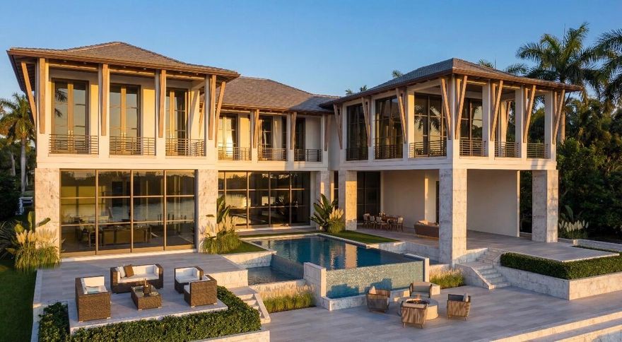 Nestled behind the private gates of Prosperity Bay Village in the heart of Palm Beach Gardens, this extraordinary modern island estate delivers the ultimate blend of architectural brilliance, refined luxury, and a premier yachting lifestyle.
Situated on over a half-acre of pristine waterfront, the newly constructed residence commands attention with clean contemporary lines, expansive walls of glass, and seamless indoor-outdoor living. A brand-new 100-foot seawall and three oversized boat slips accommodate exceptionally large vessels, offering direct access to open water with no fixed bridges a rare and coveted opportunity for serious boaters. The architecture, masterfully designed by Affiniti Architects, is complemented by expert construction from Foster Banyan Building and Development and thoughtfully curated interiors by Decorators Unlimited a collaboration that delivers exceptional quality, vision, and execution.
Inside, luxury transitional interiors balance modern sophistication with warm, artisanal detail. White oak millwork, hand-finished plaster accent walls, and custom cabinetry create a sense of craftsmanship and permanence throughout. A soft, organic palette of ivory tones, textural coral stone, and warm metal accents adds depth while maintaining a light, inviting aesthetic.
The thoughtfully designed floor plan offers grand scale and effortless livability. A soaring great room flows into a stunning chef's kitchen featuring bespoke cabinetry, refined stone surfaces, tailored metal details, and an adjacent scullery. Formal dining and a temperature-controlled wine display elevate the entertaining experience, while expansive glass doors open to covered loggias, outdoor dining and lounge areas, and resort-style waterfront entertaining spaces.
The first-floor primary suite is a private retreat with serene water views, dual walk-in closets, and a spa-inspired bath appointed with honed stone and warm wood finishes. Every space reflects intentional material selection and timeless design.
Upstairs, an oversized club room becomes a true focal point of the home a dramatic yet inviting space designed for entertaining on a grand scale. Framed by expansive glass and opening to a generous private balcony, the room captures incredible water views and coastal breezes, creating a seamless indoor-outdoor experience. Whether hosting evenings with guests, enjoying sunset views, or creating a dedicated media or lounge environment, this elevated space offers flexibility and impact. Multiple guest suites, including a VIP suite with private balcony, along with a loft, craft room, second laundry, and secure safe room provide exceptional functionality for multigenerational living.

Additional highlights include a private elevator, guest suite on the main level, mudroom, oversized laundry room, and an impressive four-car garage configuration with dedicated golf cart storage. Above the garage, a versatile wellness area is designed to accommodate a range of possibilities from sauna and cold plunge to fitness studio, golf simulator, office, or Captain's quarters.
Designed for those who demand both elegance and adventure, this waterfront masterpiece pairs refined interiors with serious dockage capability a commanding and rare opportunity in Palm Beach Gardens.