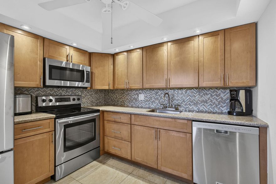 Welcome to this beautifully renovated 2 bed 2 bath spacious condo which features tiled floors throughout, built in microwave, dishwasher, all SS appliances, central Air and ceiling fans, Hurricane windows on the large Lanai and Hurricane shutters on the front windows, recessed lighting in the kitchen, nicely tiled back-splash, doors were replaced with 6 panel doors, plenty of closet space and a large walk-in closet in the main bedroom. Extra storage cage in the common laundry room, there are 2 laundry rooms on every floor.  This spectacular unit comes furnished, the 2 newer bedroom mattresses and swivel chairs on the Lanai are from Baer's furniture, the furniture in the guest bedroom, the coffee table, tan armchair and ottoman are newer the master bedroom furniture is quality brand and solid white oak with indented handles. the lovely console under the   TV is a lovely vintage piece. The Kitchen features nicely tiled back splash and recessed lighting. this well maintained no assessment building is equipped with an elevator. Enjoy your very spacious lanai with breathtaking long views of the huge lake. The building is right next to the heated Wellington residence swimming pool which has bathrooms showers changing area and sauna. The Wellington J building also has a lovely barbeque patio to enjoy with family and friends.  Century Village has many activities, some of the amenities are Listed below   Clubhouse Amenities: -Shuffleboard -Bocci Ball -1200 seat theater for shows and movies. -Numerous clubs to join. -Hasting's fitness center with complete fitness center, heated pool, the Lazy River resistance pool chair yoga, pool aerobics plus much more. -Sailing on the lakes of Century Village, don't know how to sail, no worries they have lessons. -Tennis/Pickleball -Indoor saltwater swimming pool, plus many swimming pools to choose from throughout the community -Duck Island with pier: picnics, barbeques, gatherings or just relaxation. -Community bus to transport you inside the village and outside the village for shopping, dining and much more. - hair/nail salon and barber located in the village. -Library -Dance/Party room -Pool table and ping pong room Billiards Room Wood Shop -And so much more, call me today for a private showing