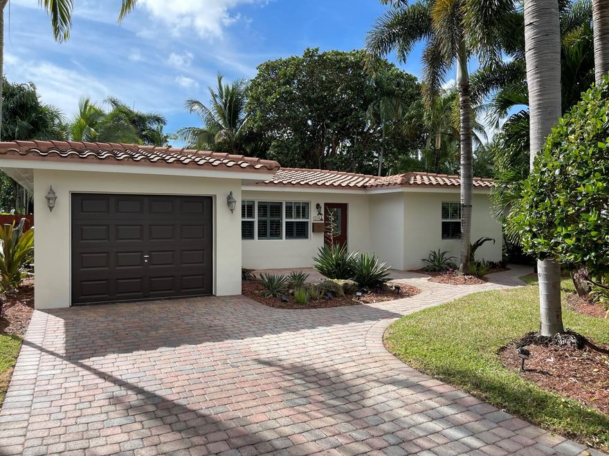 Beautifully updated mid-century home located in an excellent neighborhood of Poinsettia Heights. Easy access to Wilton Drive, beaches, and downtown Fort Lauderdale. Split floor plan and a true 3 bedroom. Master has a unique screened porch overlooking a lush tropical backyard and features a walk-in closet. Great open feel as you walk in with a unique decorative fireplace accents the living room and a spacious kitchen featuring Martha Stewart cabinets, stainless steel appliances and quartz countertops. Awesome curb appeal with fruit & native Florida trees, professionally landscaped & beautifully lit at night. The home also features a tankless water heater, newer appliances, & HVAC system.