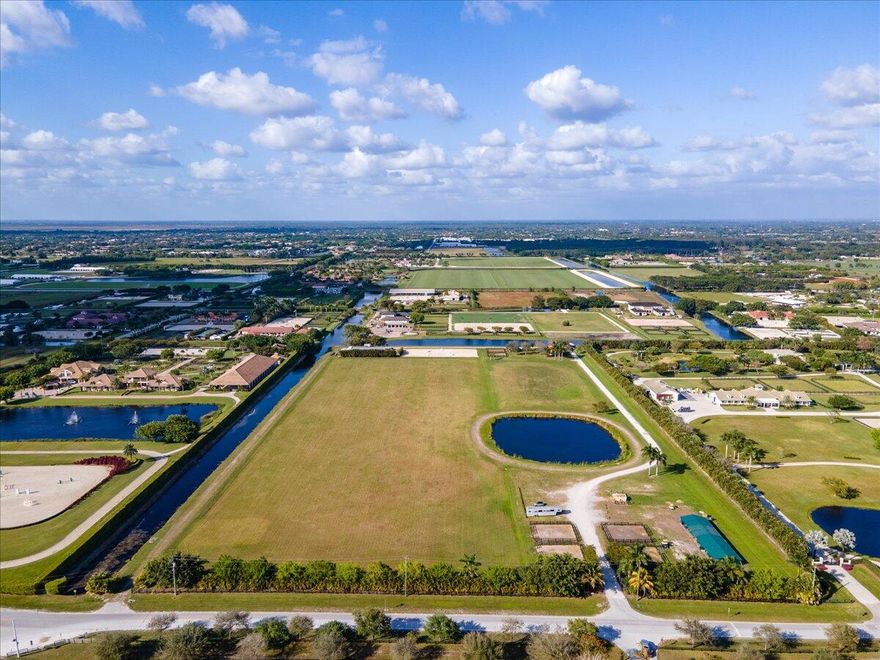 Turn your dreams into your reality. Amazing 20.87 acre horse farm could be yours.  Tremendous development opportunity. Currently on the vast property there is a 4 bedroom 4 bathroom home with impact glass, a  barn with 14 12 x 12 stalls underneath, 4 wash racks, a manure bin, an irrigated  GGT ring, a large grass riding field, a regulation length N/S polo field, 6 RV hook ups, water and electric throughout. ALL OF THIS in hacking distance to the horse show. This dream property is surrounded on 2 sides by canals, and a row of mature areca palms on the other 2, affording you privacy, peace and quiet.  This is the very last large plot of land in hacking distance to the horse show, do not let this opportunity slip away. Priced BELOW market for immediate sale. Subdivision possible