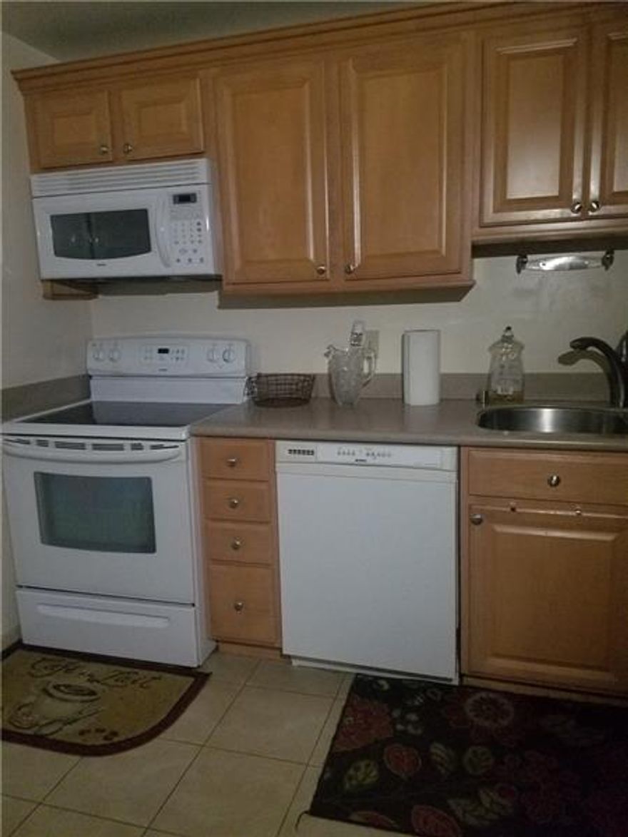 Amazing unit with tile floors overlooking the lake, featuring updated kitchen and bathrooms, in-unit laundry, and resort-style amenities at International Village including outdoor and indoor heated pools, jacuzzi, sauna, spa, gym, business center, tennis courts, barbecue area, and more.