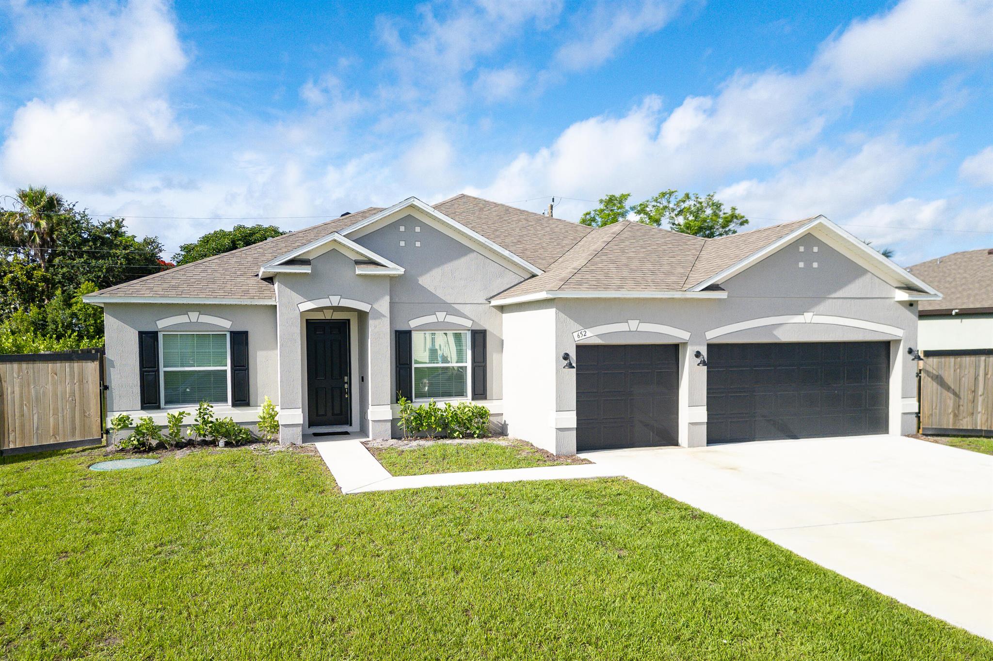 Welcome to 652 SW McCoy Avenue in beautiful Port St. Lucie--a nearly new home built in 2023 that blends modern elegance with functional design. This spacious 4-bedroom, 3-bathroom, PLUS A DEN residence offers over 2,400 square feet of thoughtfully designed living space, ideal for both everyday living and entertaining. From the moment you step inside, you're greeted by soaring 9'3'' volume ceilings and a bright, open-concept layout that features a large great room and a flexible den space perfect for a home office or playroom. The gourmet kitchen is a chef's dream, complete with upgraded cabinetry, solid surface countertops, and stainless appliances. Ceramic tile, offering both style and easy maintenance. retreat to the generous primary suite or unwind on the covered porch. 3 car garage.