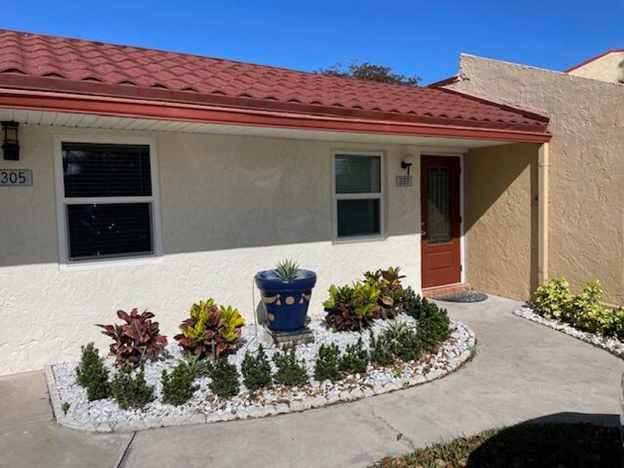 This beautifully renovated corner villa offers a perfect blend of comfort and style, set against a serene lakefront backdrop. The home features elegant porcelain tile flooring throughout, impact-resistant glass windows, and a fully enclosed, air-conditioned patio with glass panels and window treatments—ideal for year-round enjoyment. The kitchen is thoughtfully updated with stainless steel appliances, rich wood cabinetry, and a convenient pantry. Enjoy breathtaking lake views that create a tranquil, retreat-like atmosphere right at home. Located in the gated community of Golden Lakes Village, residents have access to a wide range of amenities.