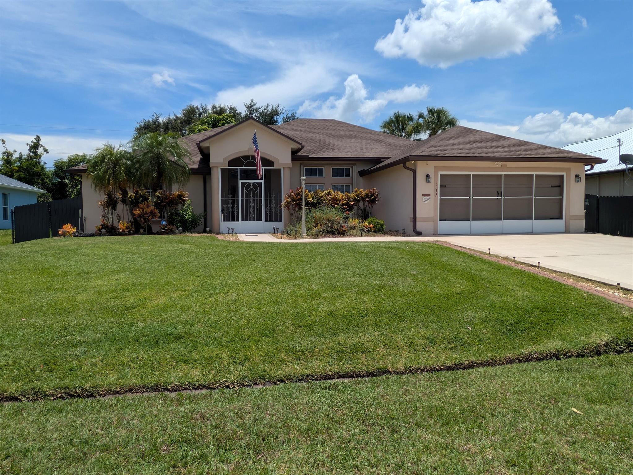 This is a beautiful home that is spacious and well-maintained. The roof is new as of 2022. Hardwood floors in the bedrooms and laminate in other living areas. The large master suite has a door that leads out to the huge, screened patio. The master bath has a jetted tub and large walk-in shower. The split floorplan offers two more bedrooms with walk-in closets. The guest bath is a cabana bath with a door leading out to the screened patio. The kitchen has a ton of cabinet space and a large island/bar. Upgraded cabinetry has pull out shelves in lower cabinets. There is an indoor laundry room that leads to the air-conditioned garage with an extra refrigerator and screens that cover the garage opening. The screened patio leads out to a lushly landscaped fenced back yard. There is a