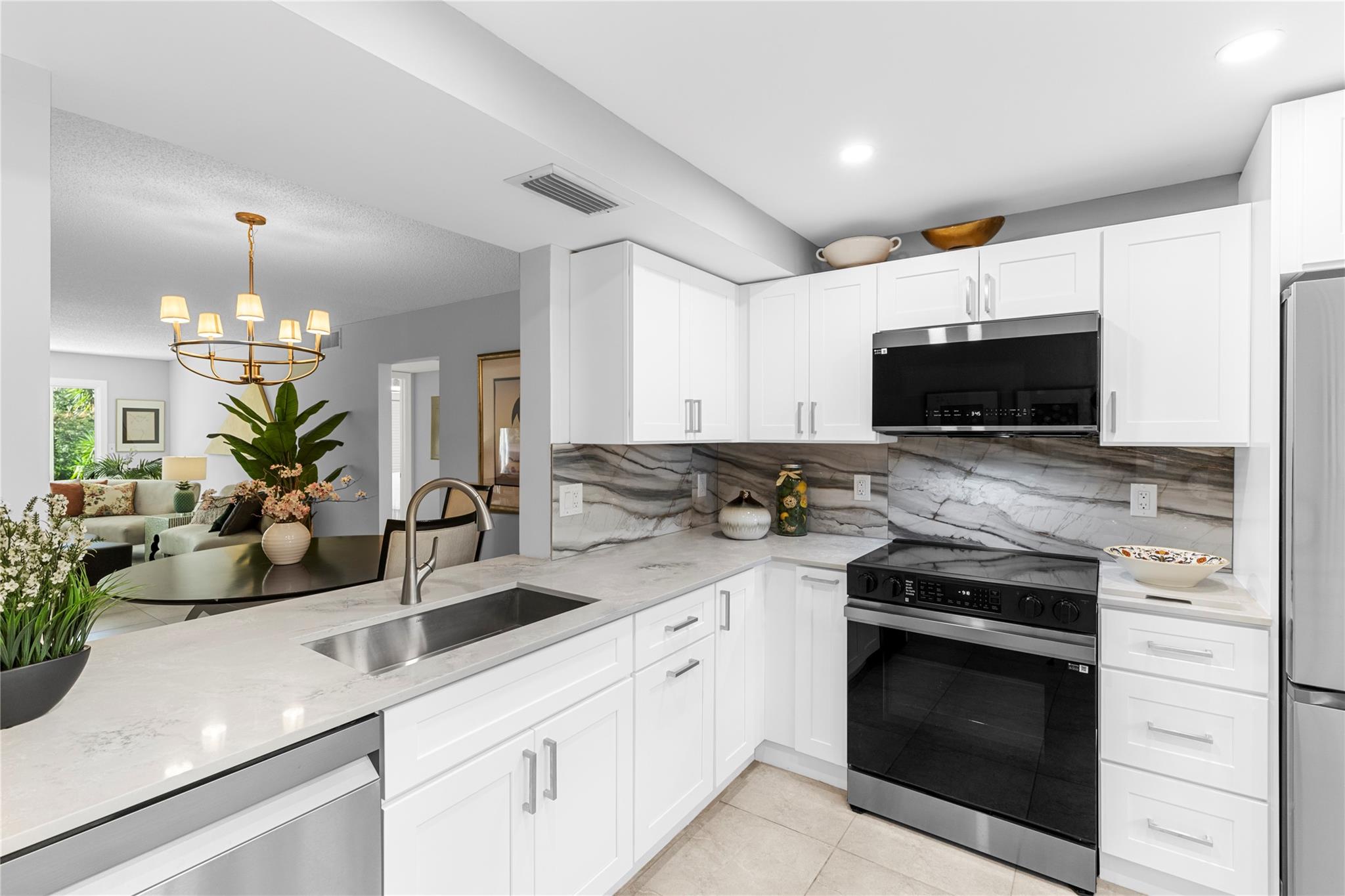 Absolutely Stunning Remodel! Feel the Luxury at the prestigious, guard gated 55+ Wynmoor Community. The kitchen features quartz countertops & top of the line SS appliances w/ air fryer in range; 30” soft close drawers/cabinets w/ pull out shelves;& imported Spanish tile in both baths. Enclosed balcony w/ sliding impact windows & floor to ceiling Impact Glass Windows. New front door, plumbing, fixtures, water tank, & electric panel. Building has new roof, passed 40 yr w/o repairs & there's reserves in budget; monthly fee now includes Internet service. There's pickleball/tennis courts; @ the clubhouse you can play billiards, join a club, eat at The Bistro, or play a round of golf & you only pay to play – no membership fees. Pool is directly behind the bldg & fitness center, office, & Theater